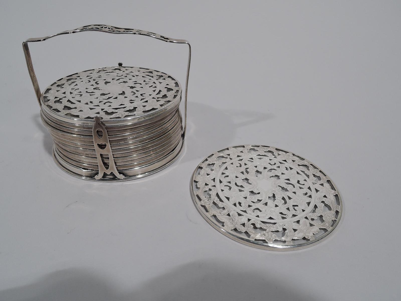 Twelve turn-of-the-century Art Nouveau glass coasters with engraved silver overlay on stand. Made by Webster in North Attleboro. Each coaster: Flat and circular, central cartouche (vacant) surrounded by dense scrolls and flowers; border same. Glass