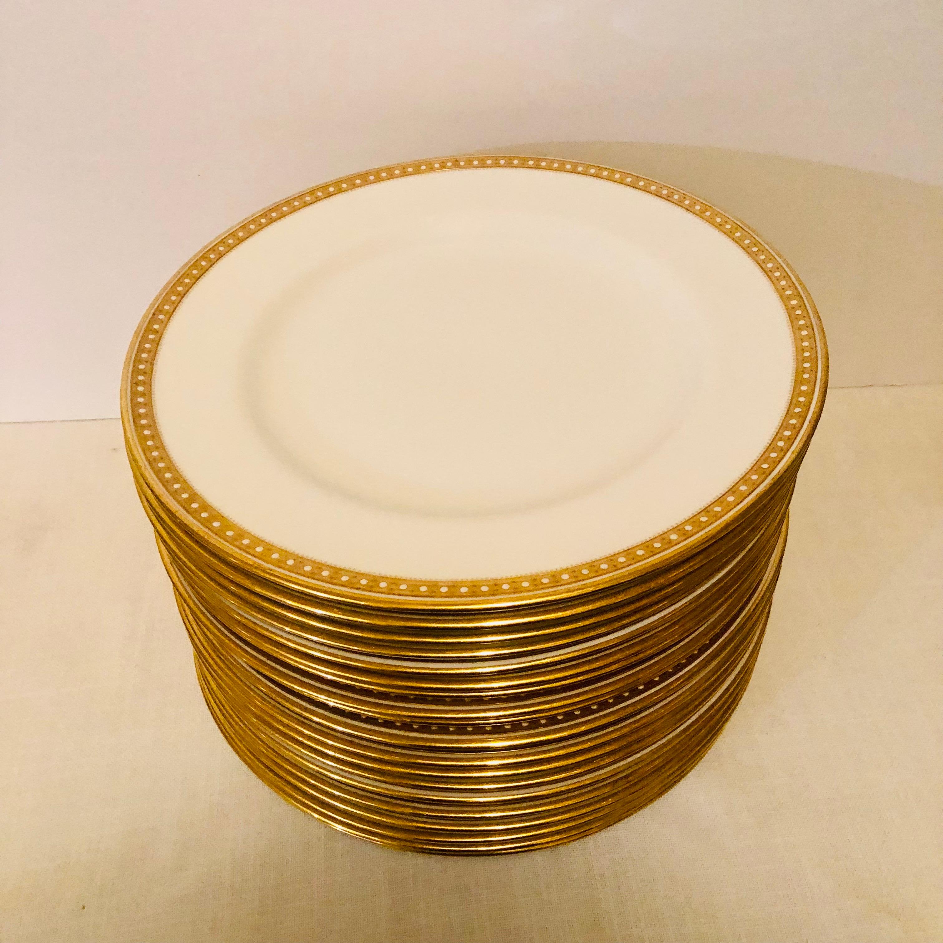 I am offering you this exquisite set of thirteen Copeland Spode dinner plates which have a gold border and white enamel jeweling on a white porcelain body. They definitely look like simple elegance, and they would look beautiful with any dinnerware