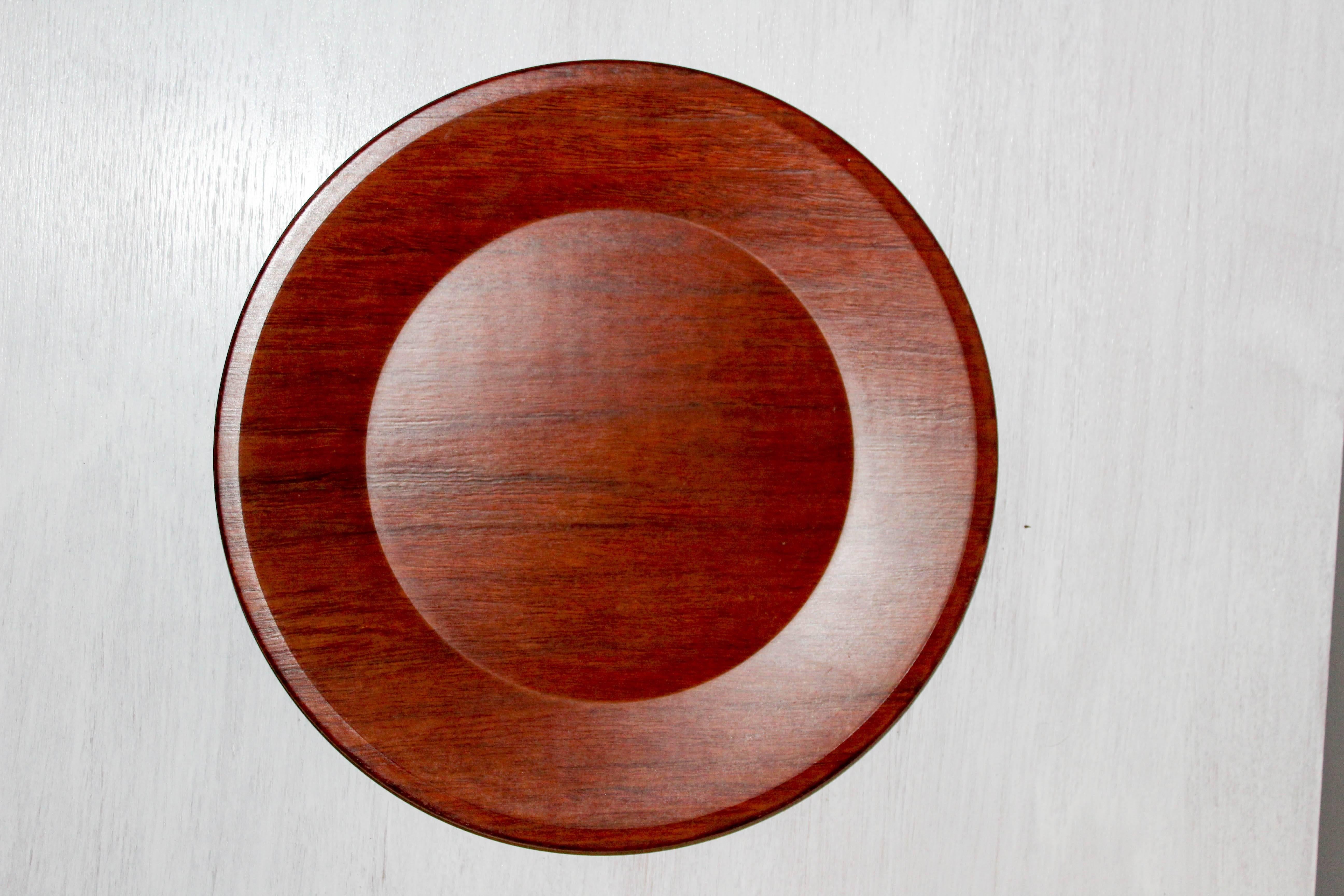 Set of 13 dining plates made out of teak, produced by Swedish company Silva. The plates are water, wine spirit and heat proof. 

The plates are in very good vintage condition with minor signs of usage. One plate is darker in color than the rest.