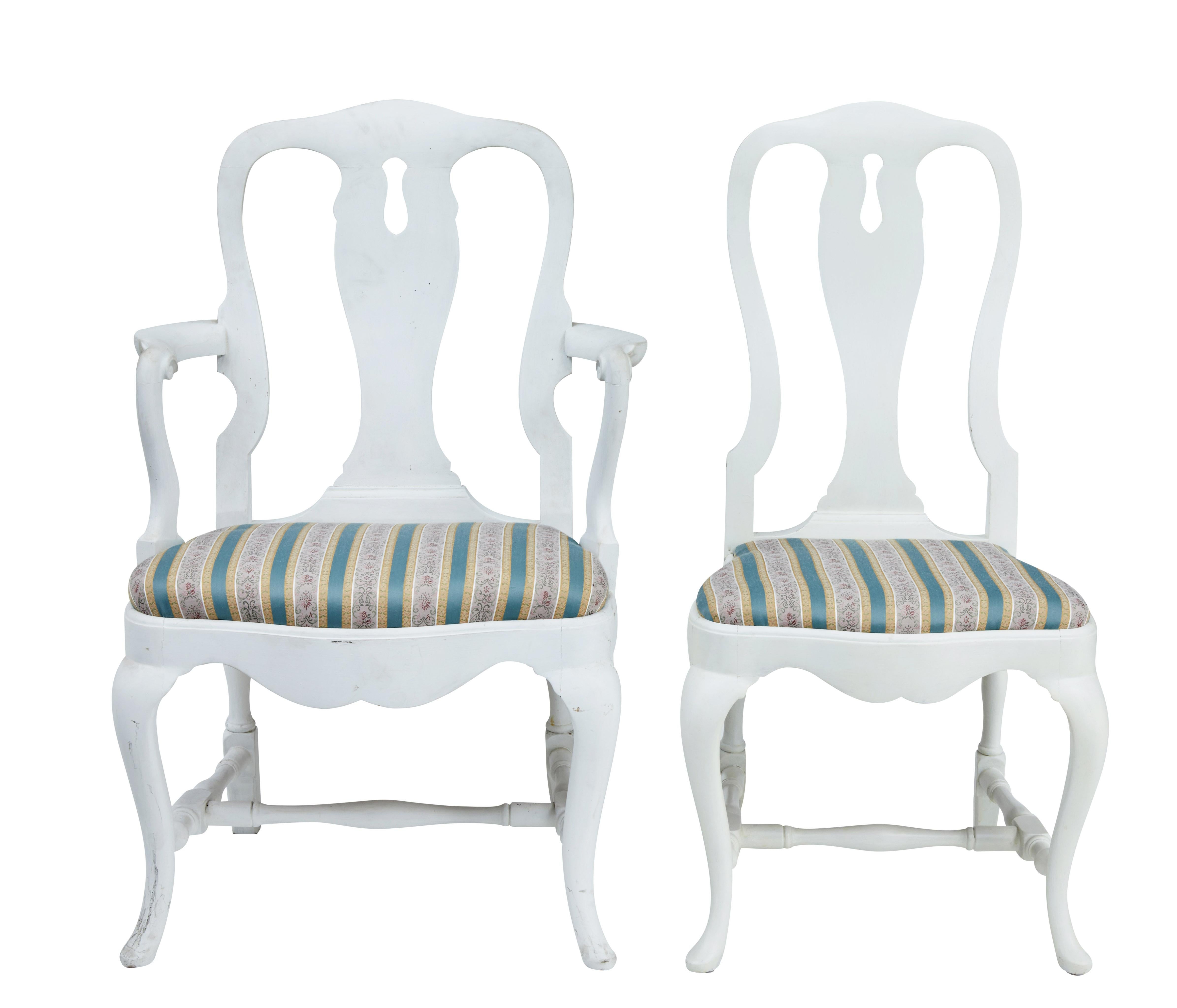Set of 14 1920s Queen Anne design dining chairs, circa 1920.

Set comprises of 12 single chairs and 2 carver armchairs. Made in beech and later painted white.

Shaped Queen Anne design backs, with drop in seats which are in good usable