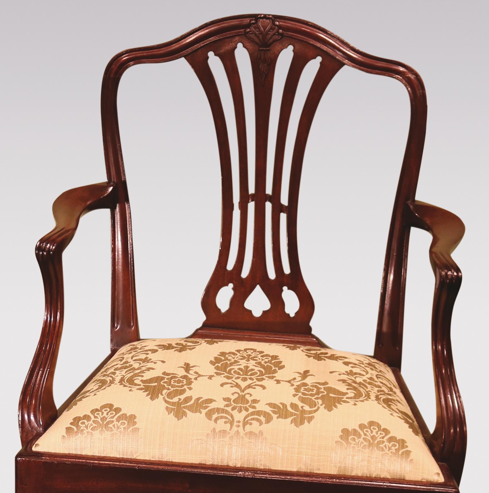 A set of 12 single and 2 arm, late 19th century Hepplewhite style camelback dining chairs, having molded backs with honeysuckle carving to the top rails, with pierced Gothic splats, supported on square top legs with 'H-stretchers'.

Armchairs