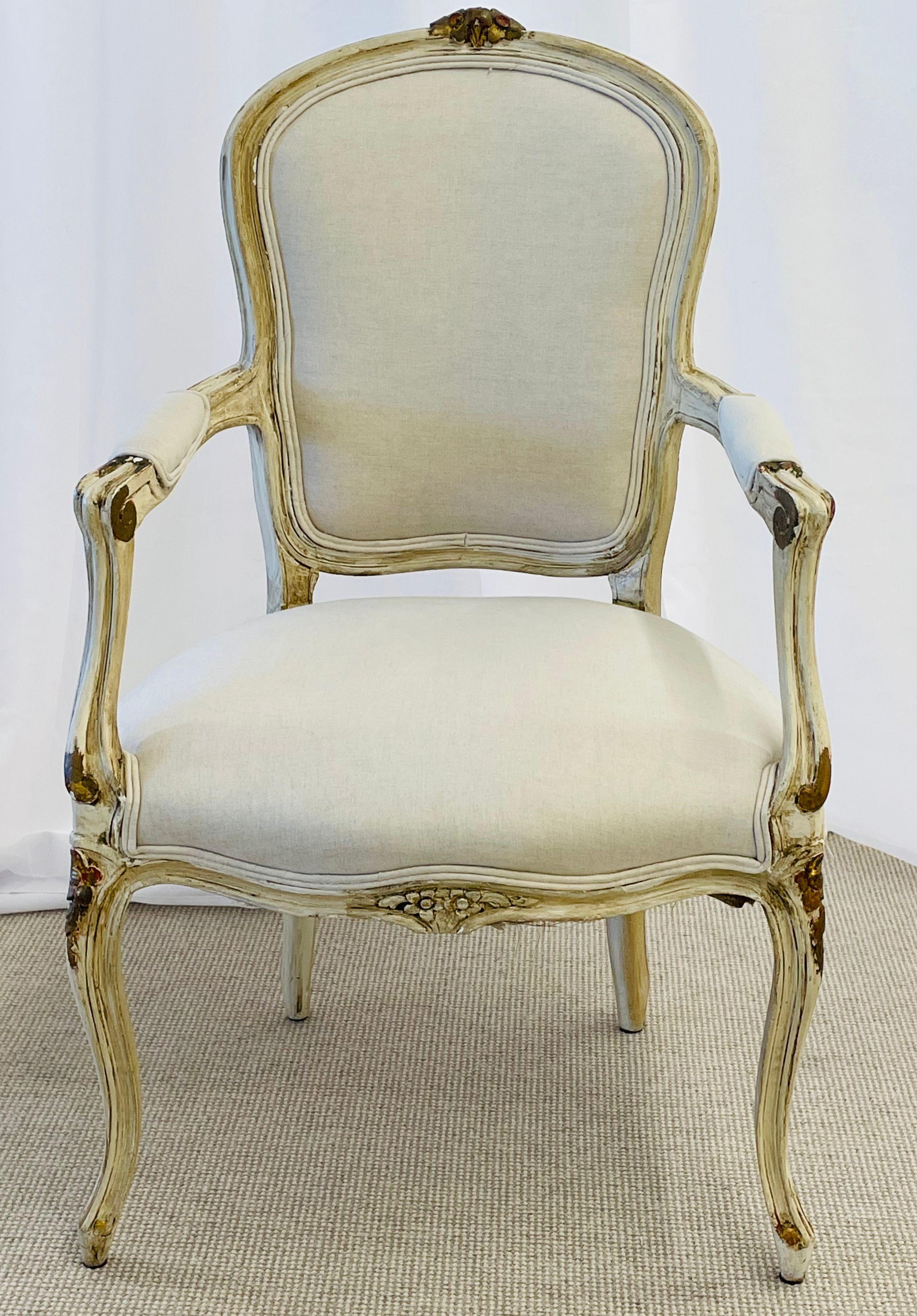 A set of 14 Maison Jansen Swedish style parcel paint and gilt decorated dining chairs. A stunning set of 14 dining chairs, many stamped Jansen, each in a cotton fabric that needs to be cleaned. The frames all paint and parcel gilt decorated with a