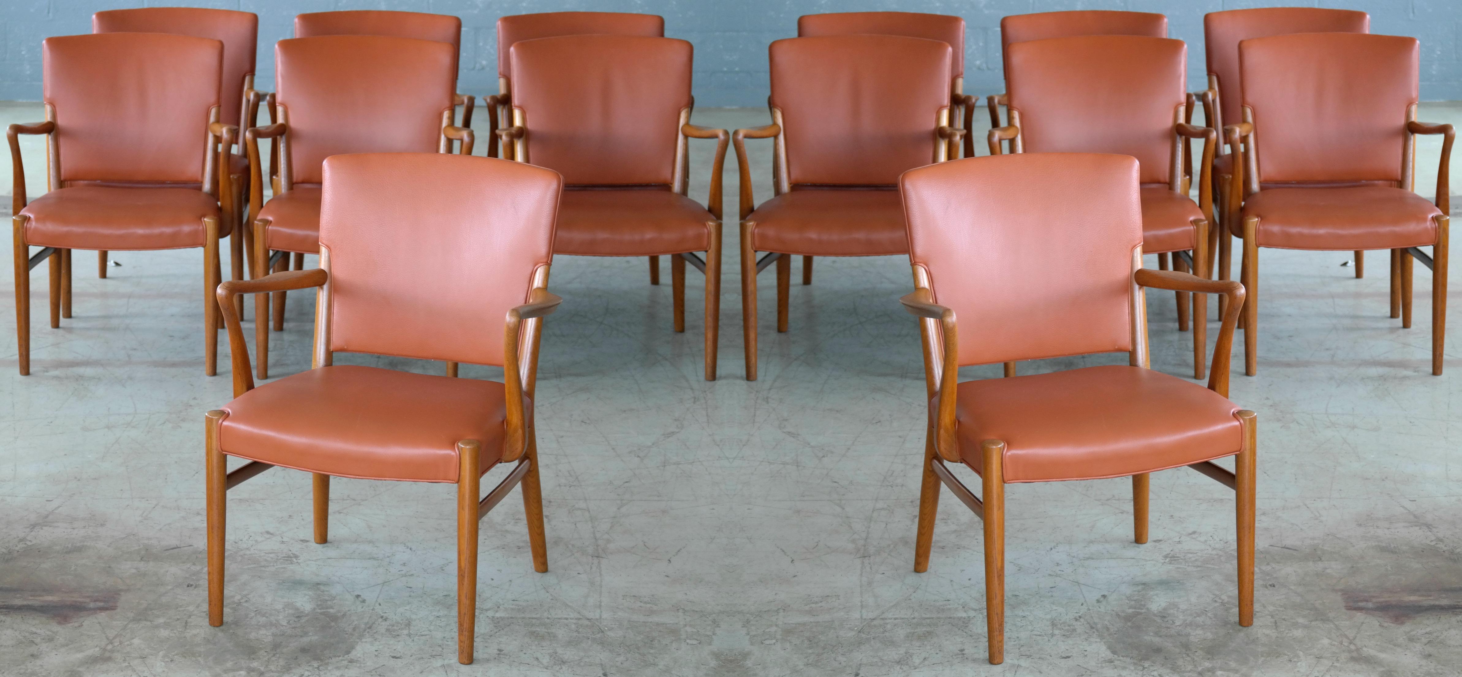 Rare to find fantastic set of 14 midcentury Danish conference chairs. Probably manufactured in the late 1960s. Beautiful armrests and legs in carved elm wood with great grain and color. The chairs are very much in the style of Fritz Hansen but the