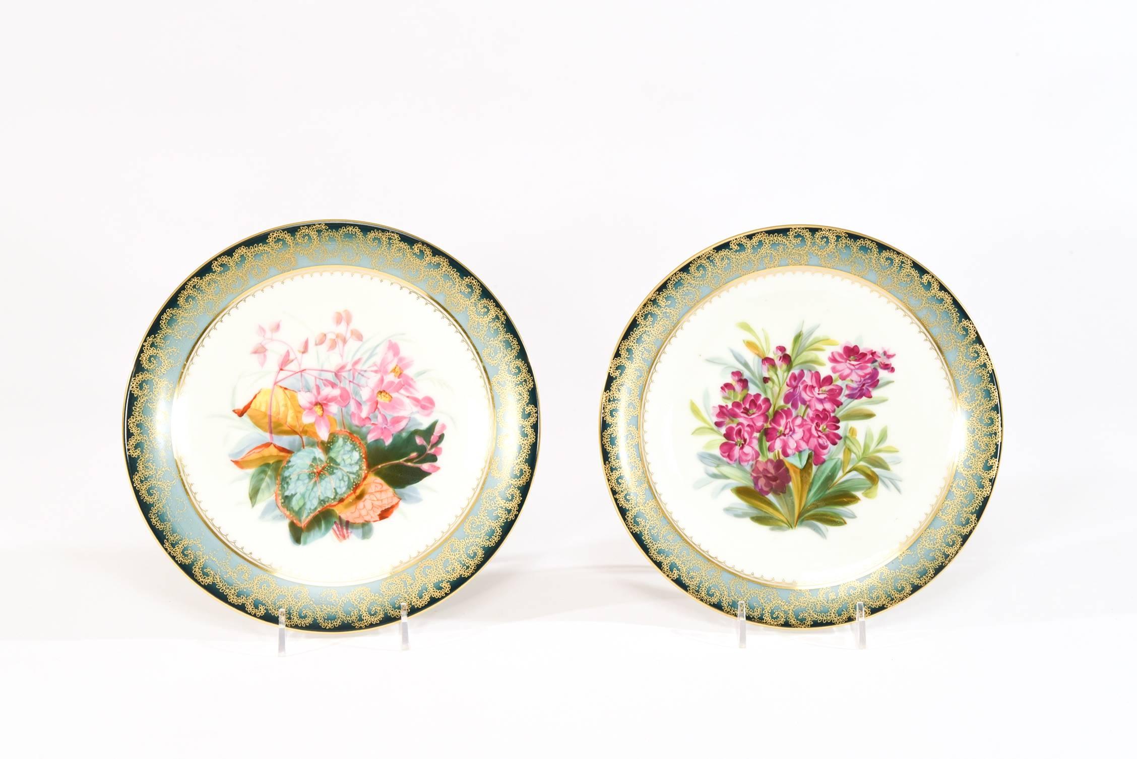 Dieses Set handgemalter botanischer Dessertteller zeigt ein lebhaftes Blumenmotiv in einer abwechslungsreichen Palette. Jeder Teller wird von einer ungewöhnlichen impressionistischen Bordüre umrahmt, die von einem dunklen blaugrünen Farbton zu einem