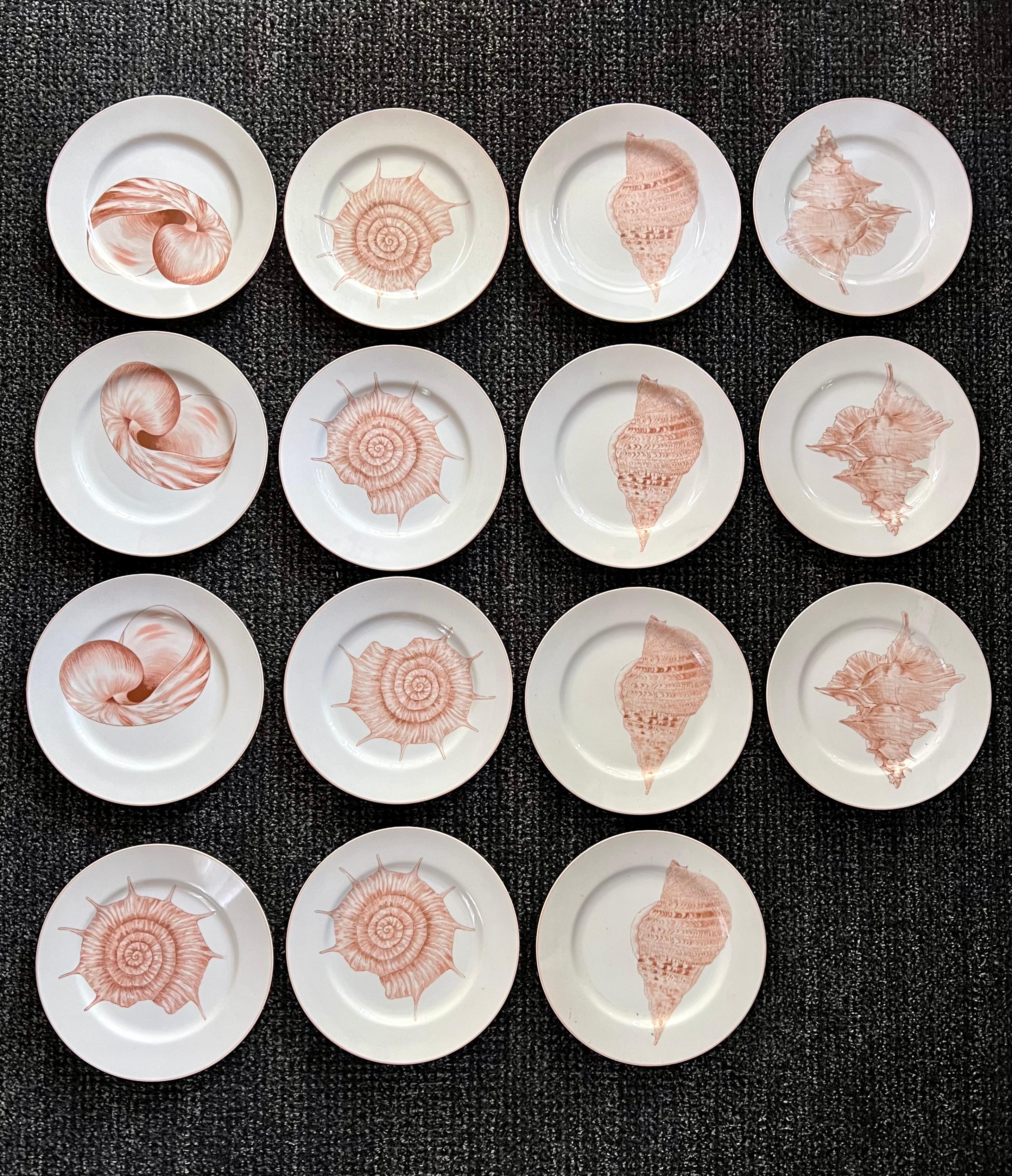 Fitz and Floyd shell themed dinner plates from the now retired Coquille collection. The set of 15 dinner plates features various 4 different shell designs. The plates have beautiful peach and coral hues, with a pink band on the edge. Wonderful to