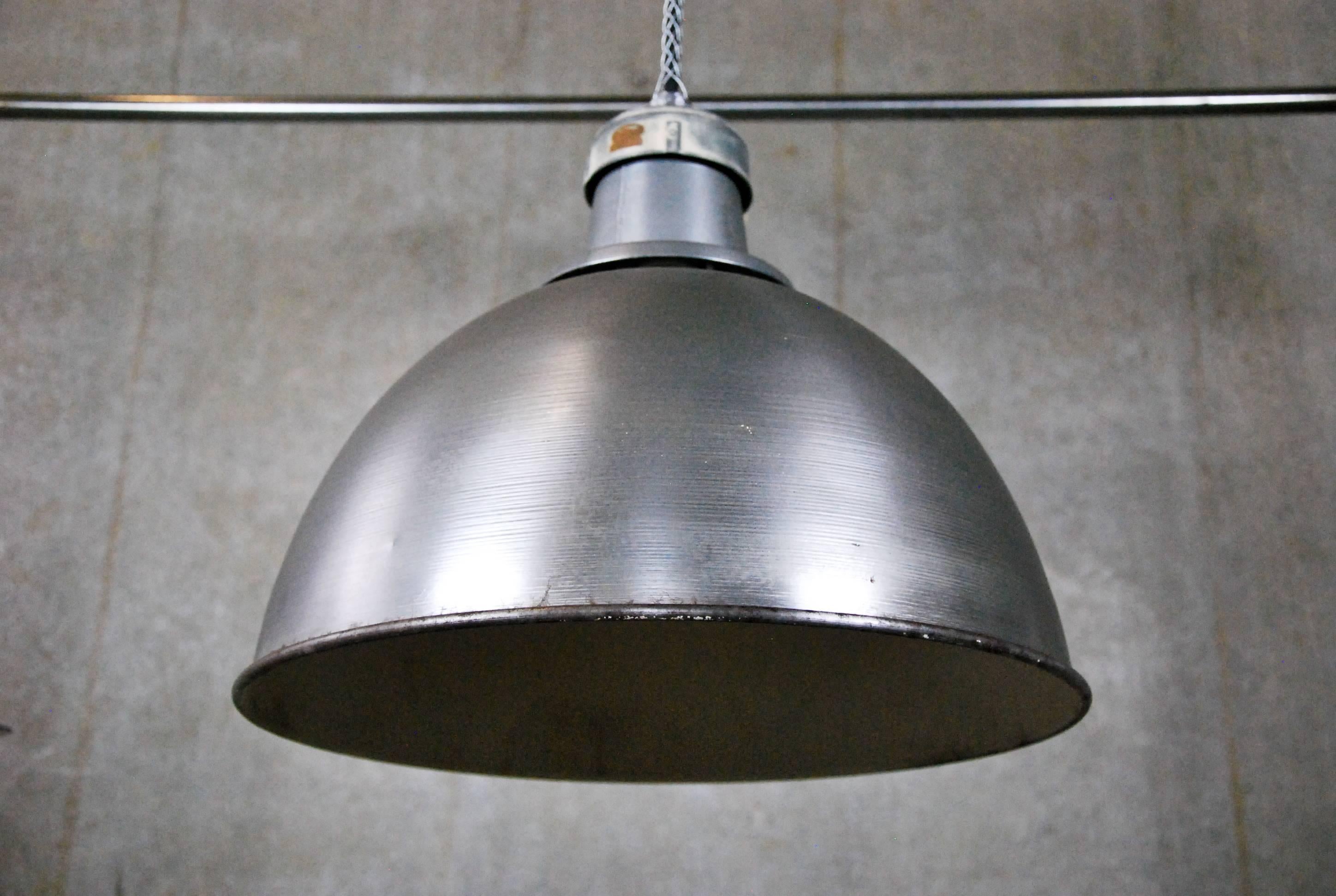 Vintage 16-inch diameter spun steel pendant lights, salvaged from a factory in Montreal, Quebec. We have 15 of these dome-shaped industrial lights. They have been re-wired and CSA approved, and currently hang on 8 feet of cable. Ceiling mounting