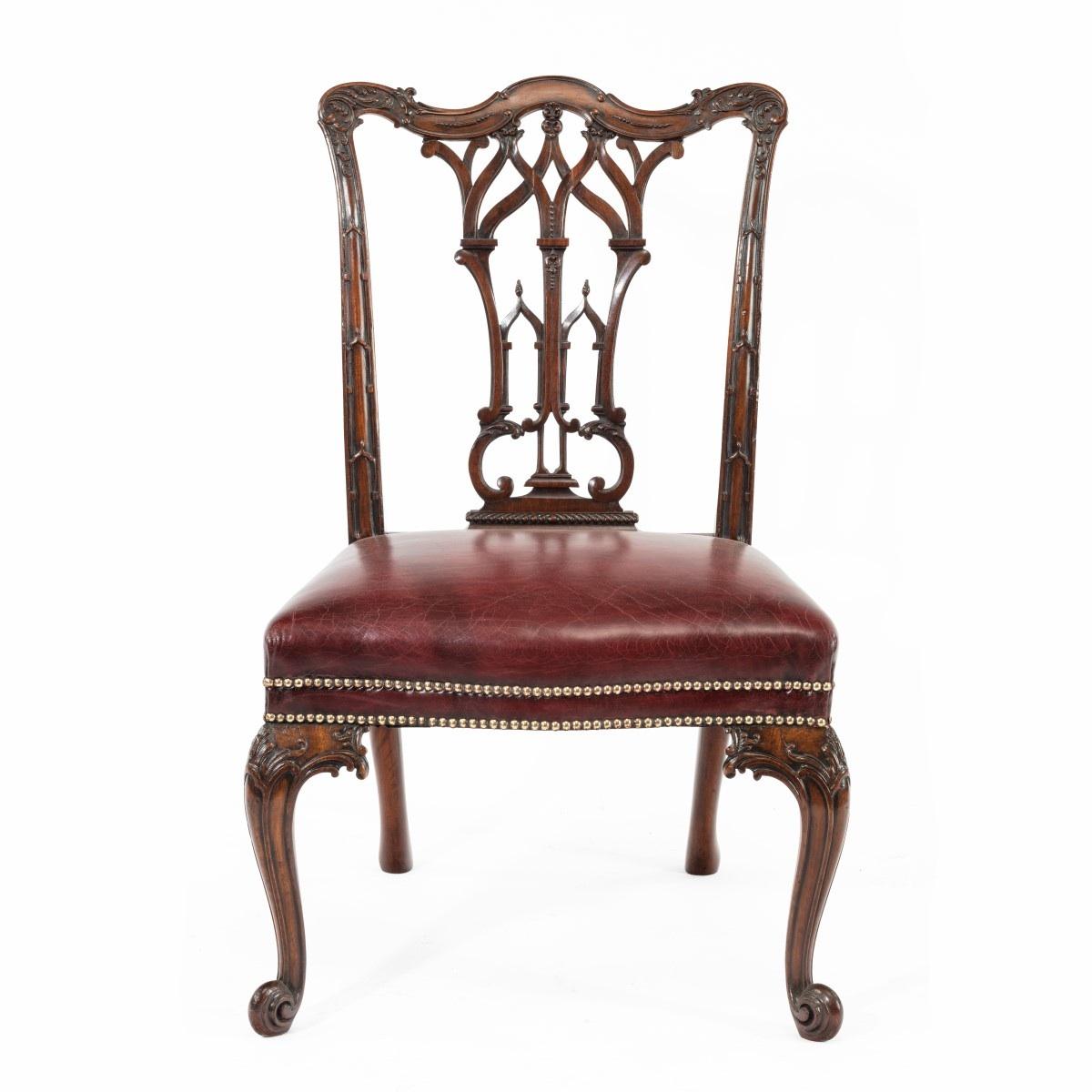 A fine matched set of 16 Victorian mahogany dining chairs in the Chippendale style, each of generous proportions with a shaped cresting rail, openwork Gothic tracery to the splat, scrolling cabriole front legs and outswept back legs, carved with