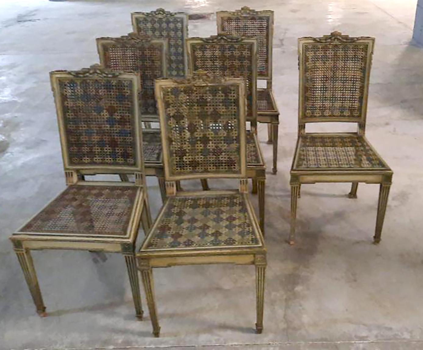 This is a fabulous set of Belgian Dining Chairs from the 18th C. The delicate green hand painted details on the frame stylize the shape whilst the diamond pattern on the caned seats and back give a fun touch to the ensemble. 8 of the chairs include