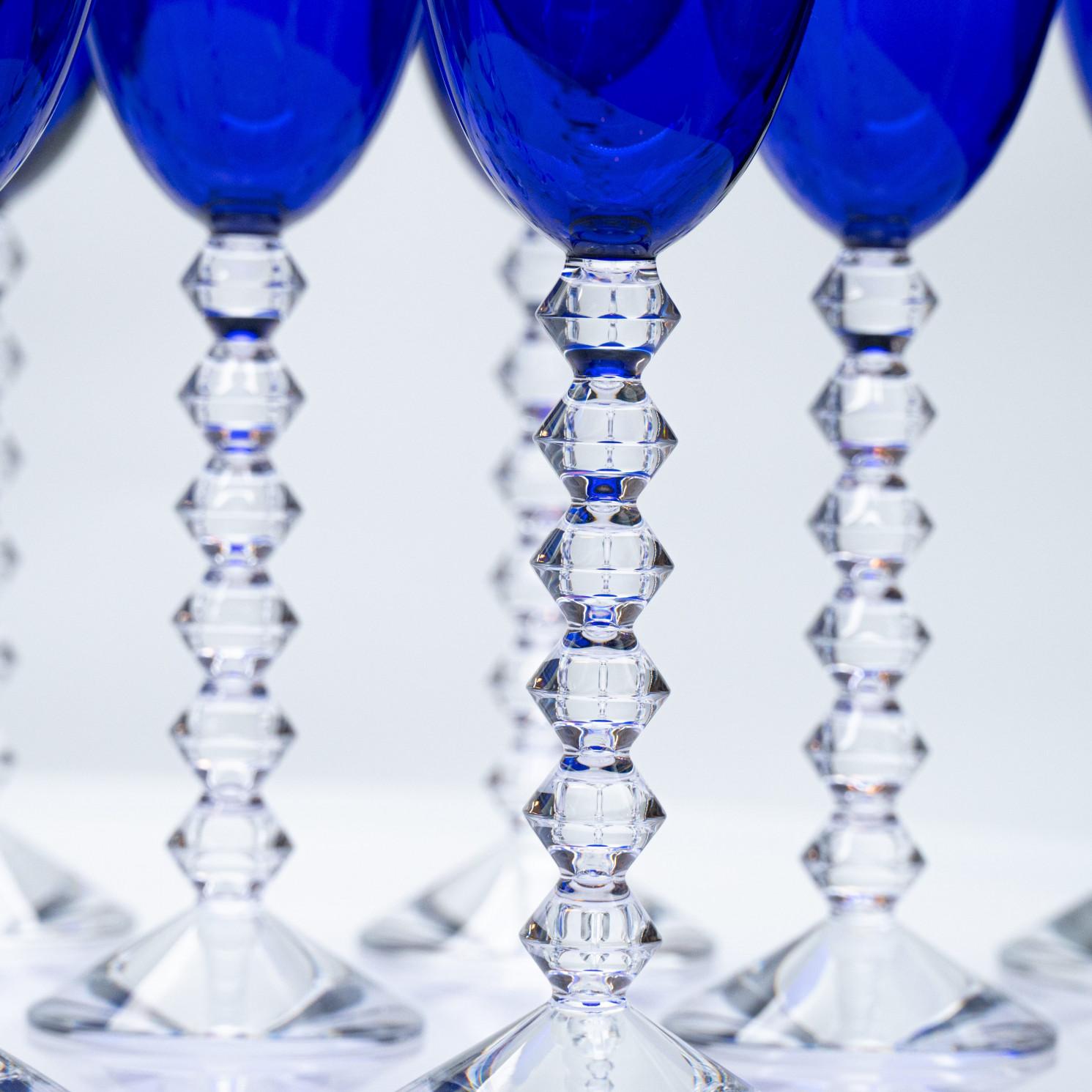 Luxury at its finest, set of 18 high-end glasses in deep rich blue crystal by Baccarat. The pure and clean bowl contrast with an angular and tactile stem. This union results in a beautiful glass that is as nice to hold as it is to drink.

Height