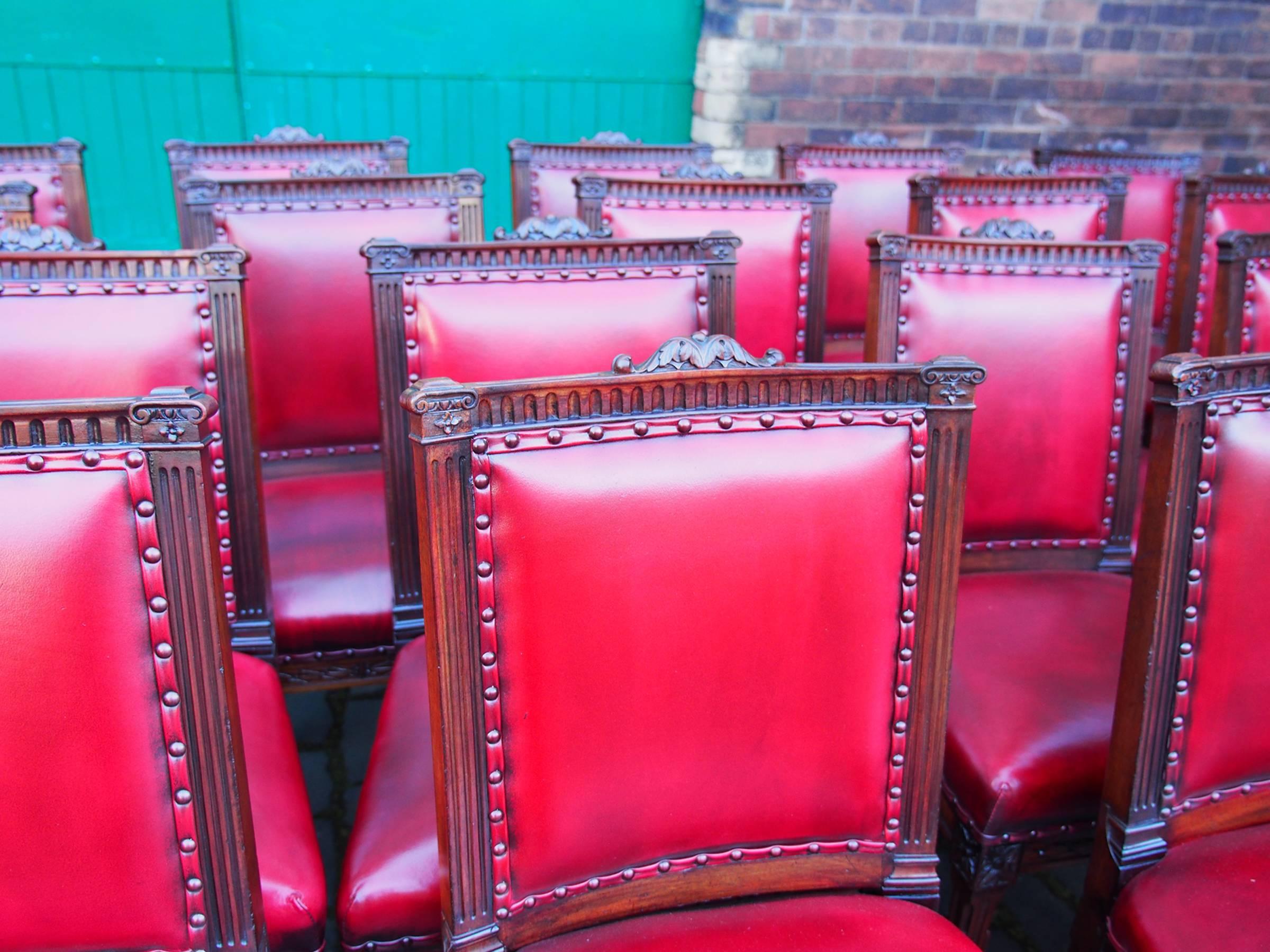 Set of 18 mahogany dining room chairs by Morison & Co of Edinburgh, circa 1900. This set of chairs have been reupholstered with deep buttoned burgundy leather. The chairs have a carved top rail, fluted up-rights and the back legs are square and