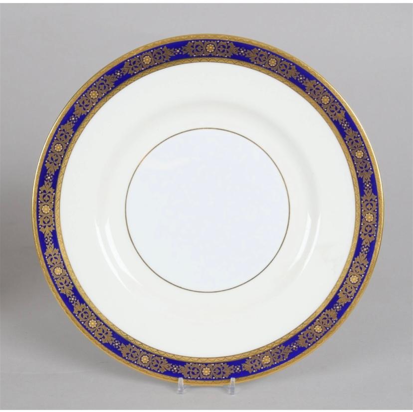 An elegant set of eighteen (18) dinner plates by one of England's re known firms Minton. This vintage set features a cobalt blue and raised paste gilt design with double 24 karat gold acid etched bands on its collar. A generous white and cream base