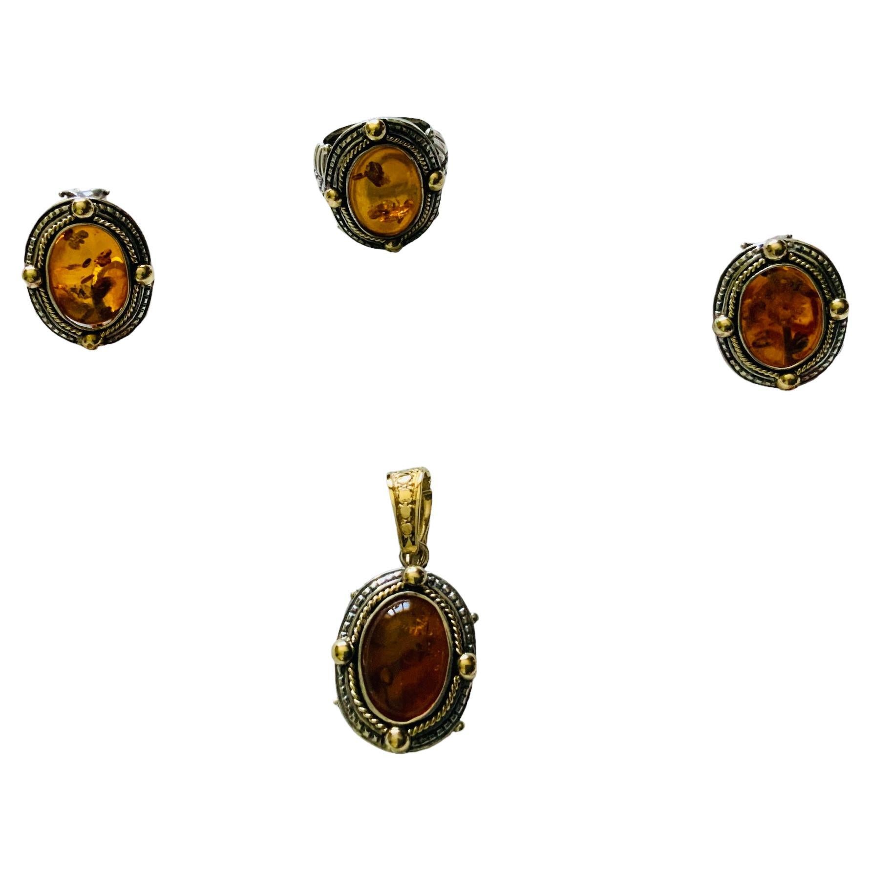 This is a set of 18K yellow gold, 925 silver and amber pair of earrings, pendant and ring. They depict an oval cabochon ambers on bezel setting decorated with an 18K gold thin ropes around them, followed by a carved 925 silver frames. Four 18K gold