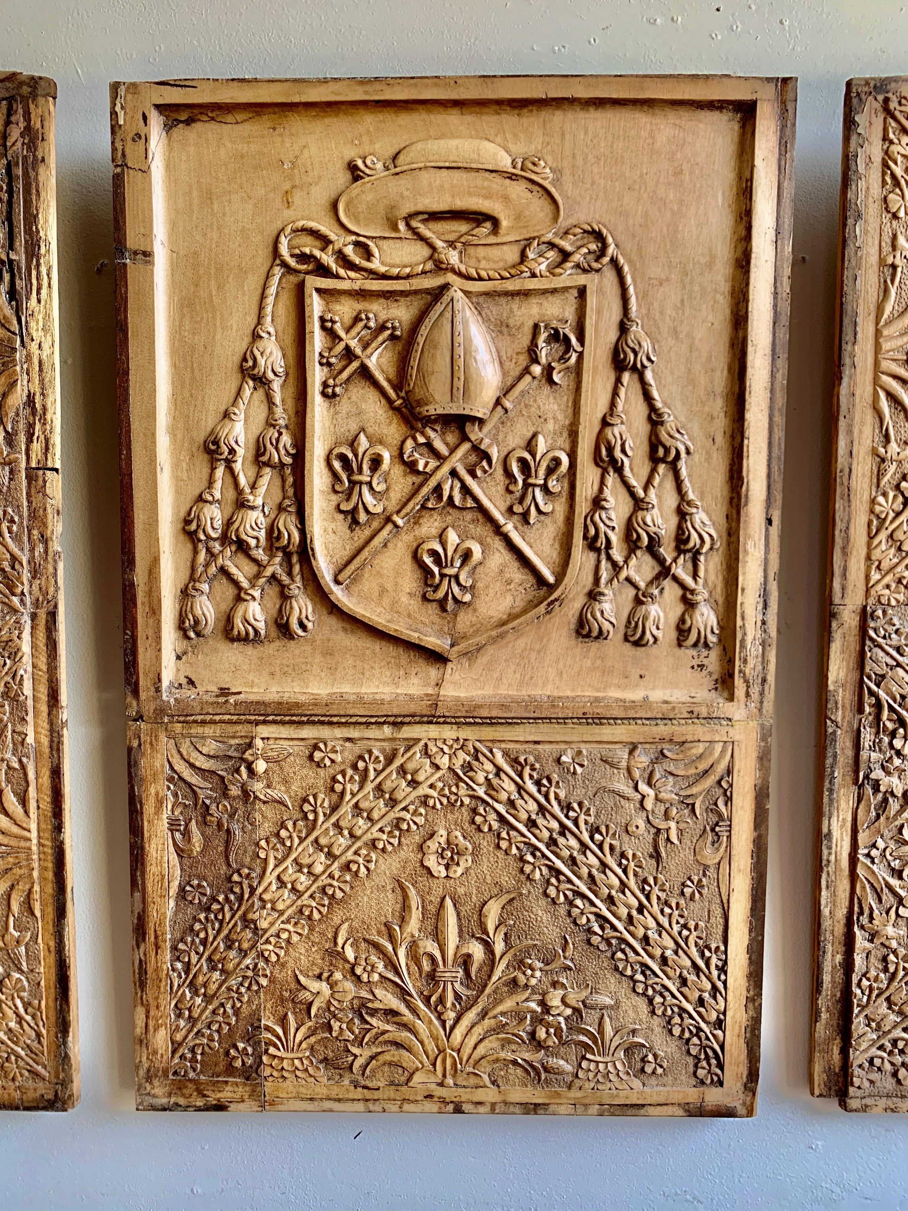Set of 18th century Spanish wood panels with fine hand carved details throughout. The center panel has a shield that is draped with carved tassels. Crossed swords are in the center with fleur-de-lis throughout. You could even attach them and make a