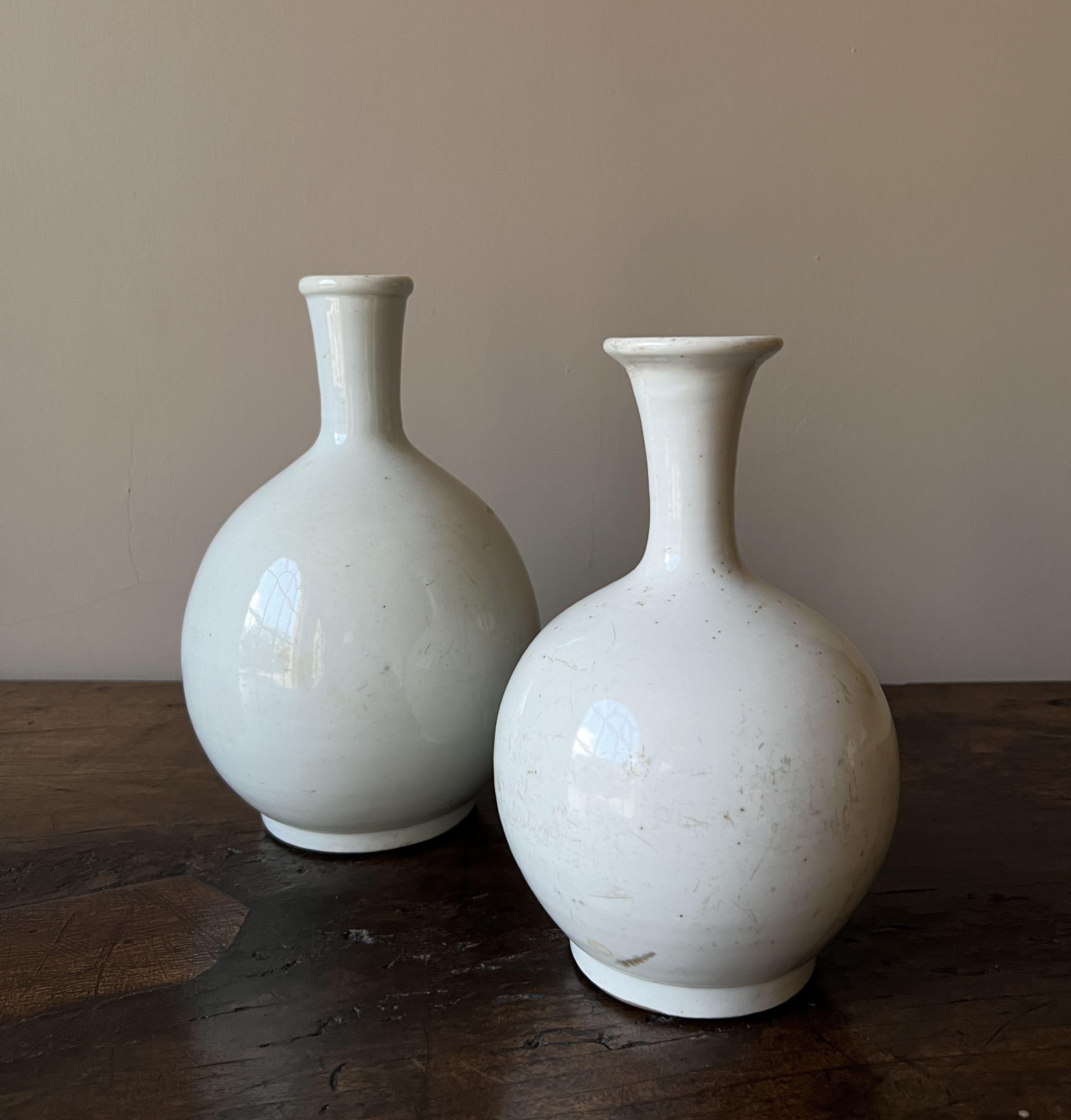 A set of 2 simular late 18th century Korean vases. Both with a fine cream color and a typical minimalistic bulb shape. White pottery like this is rare because it was only made for noble houses during the Joseon dynasty. 
Overall in very good