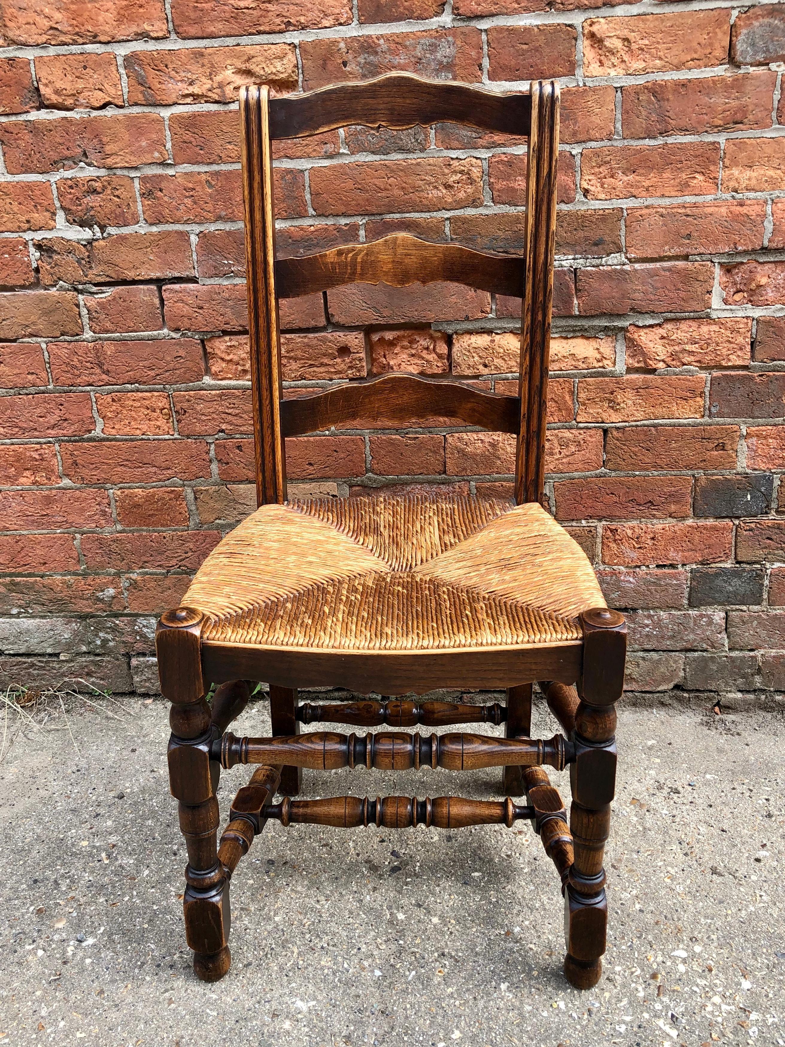 A good quality set of six 1920s French elm ladderback dining chairs with woven rush seats upon turned elm front legs with turned stretcher supports. All in good original condition.
