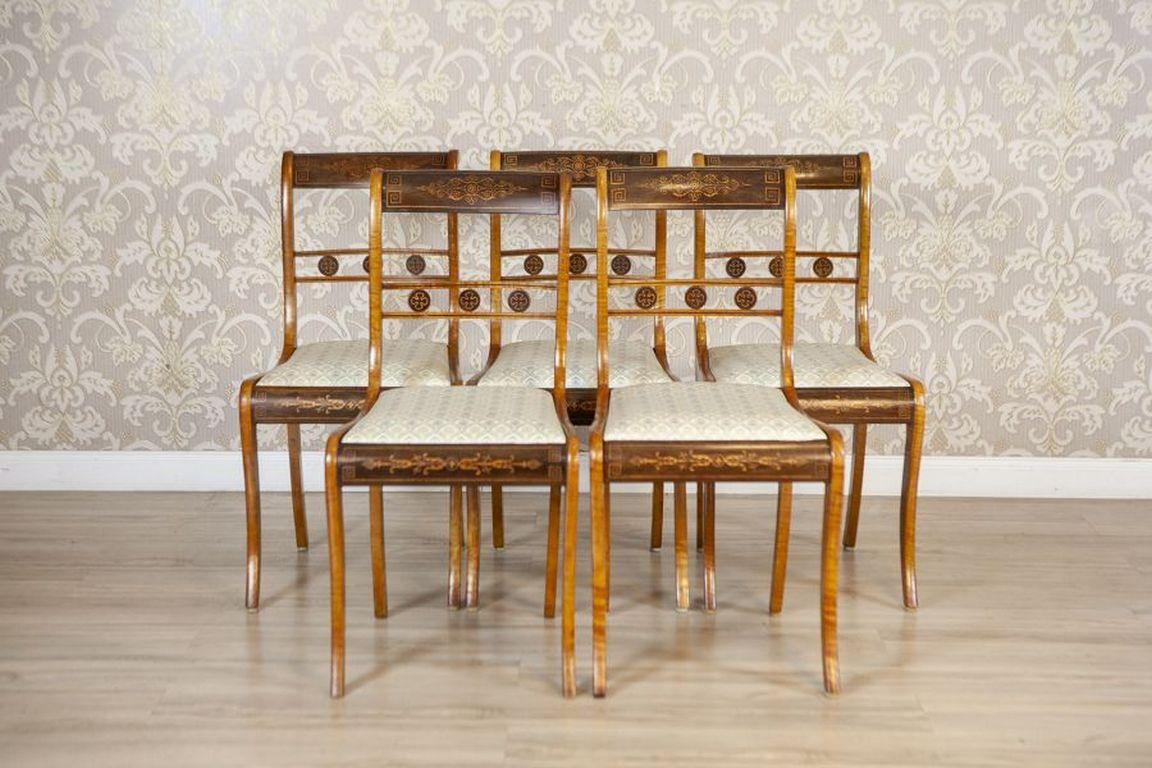 Set di sedie inglesi del XIX secolo in stile Sheraton con intarsi decorativi

Il set è composto da cinque sedie inglesi in stile Sheraton. Le sedie sono riccamente decorate con intarsi e presentano gambe dritte con una leggera curva. La tappezzeria