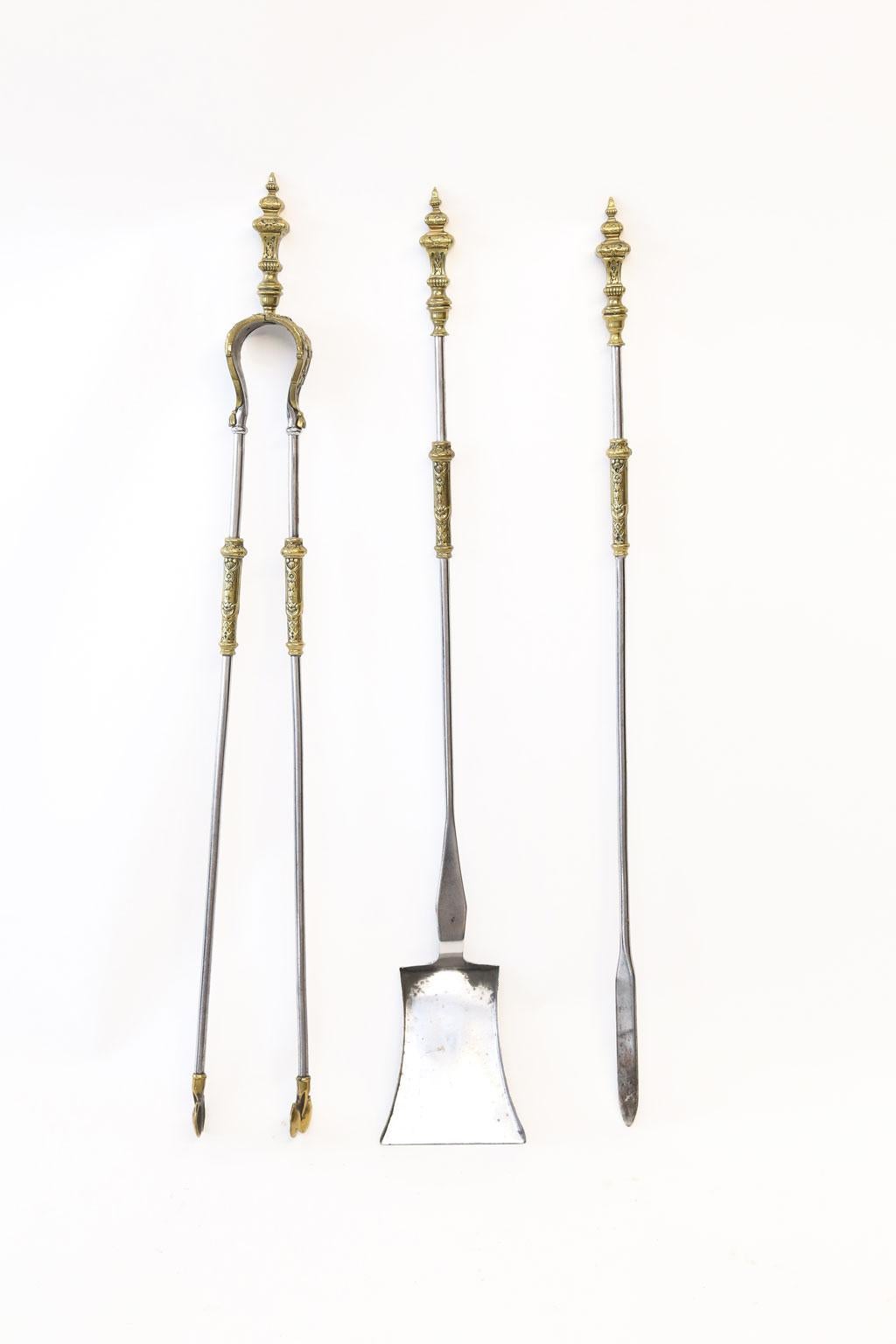 Set of 19th century English fire tools cast in steel and gilt-brass. Nice wear visible. Later application of clear lacquered finish. 

Shovel measures 2.5 inches high x 4.5 inches wide x 30 inches deep. 
Poker measures 1.13 inches high x 1 inch