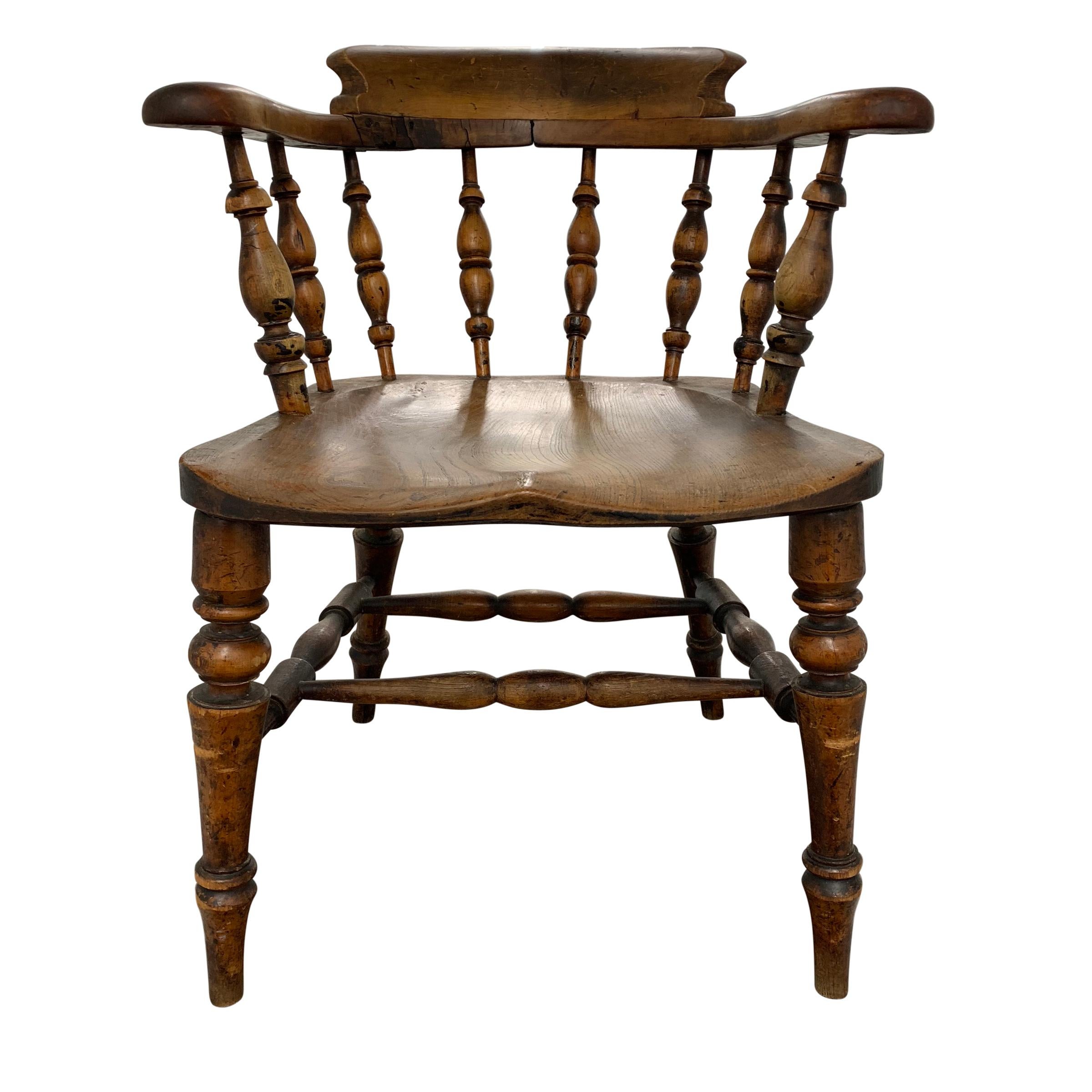 An incredible set of two almost matching 19th century English pub chairs with beautifully turned spindles and legs, with a slight lean, and fantastic patina only time can bestow. One of the chairs has a wonderful old iron repair on the back.