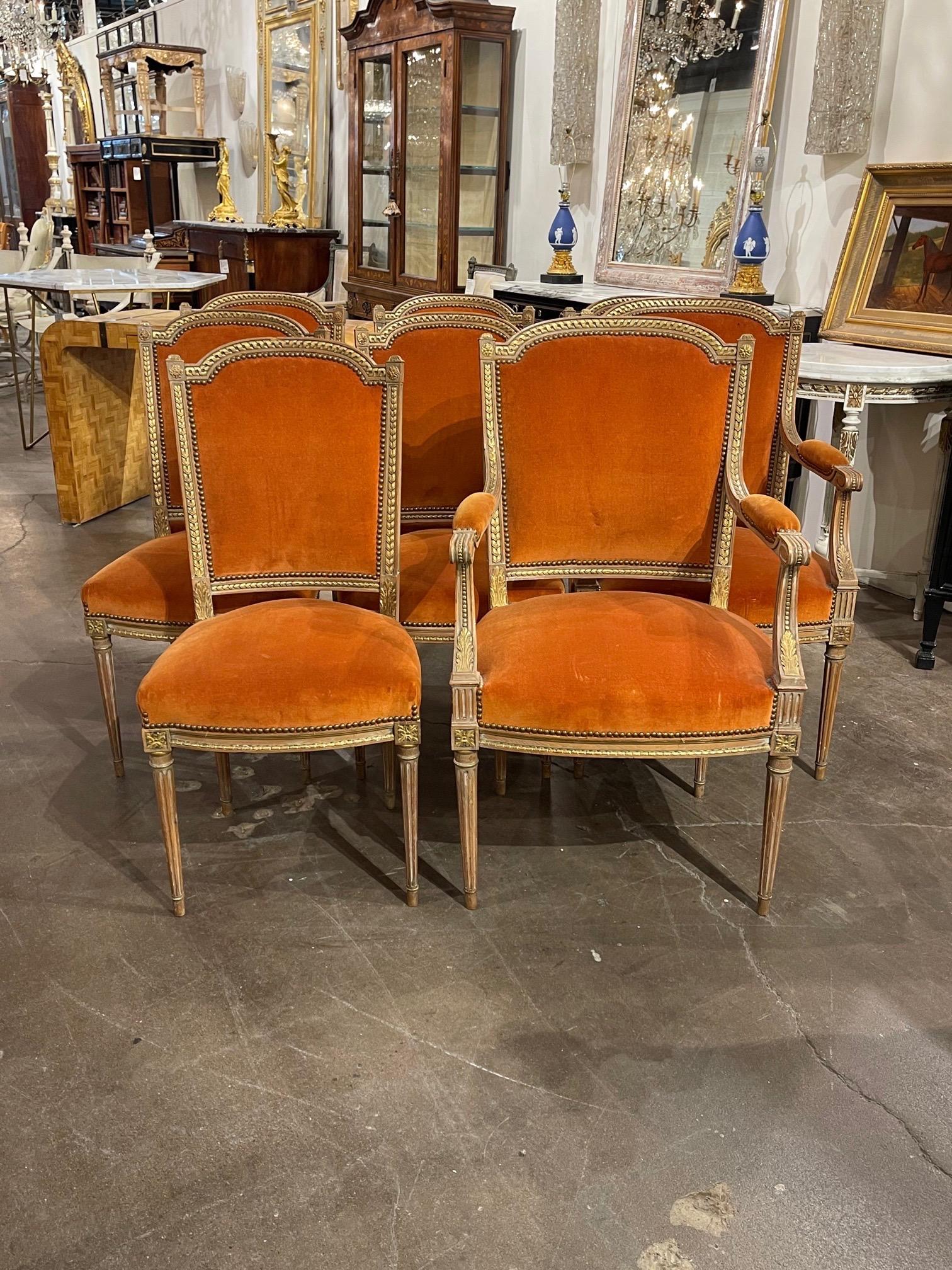 Great set of 19th dining century French Louis XVI style carved and gilded dining chairs. There are 2 armchair and 6 side chairs upholstered in an orange velour. Fabulous carving and patina as well. An exceptional set!