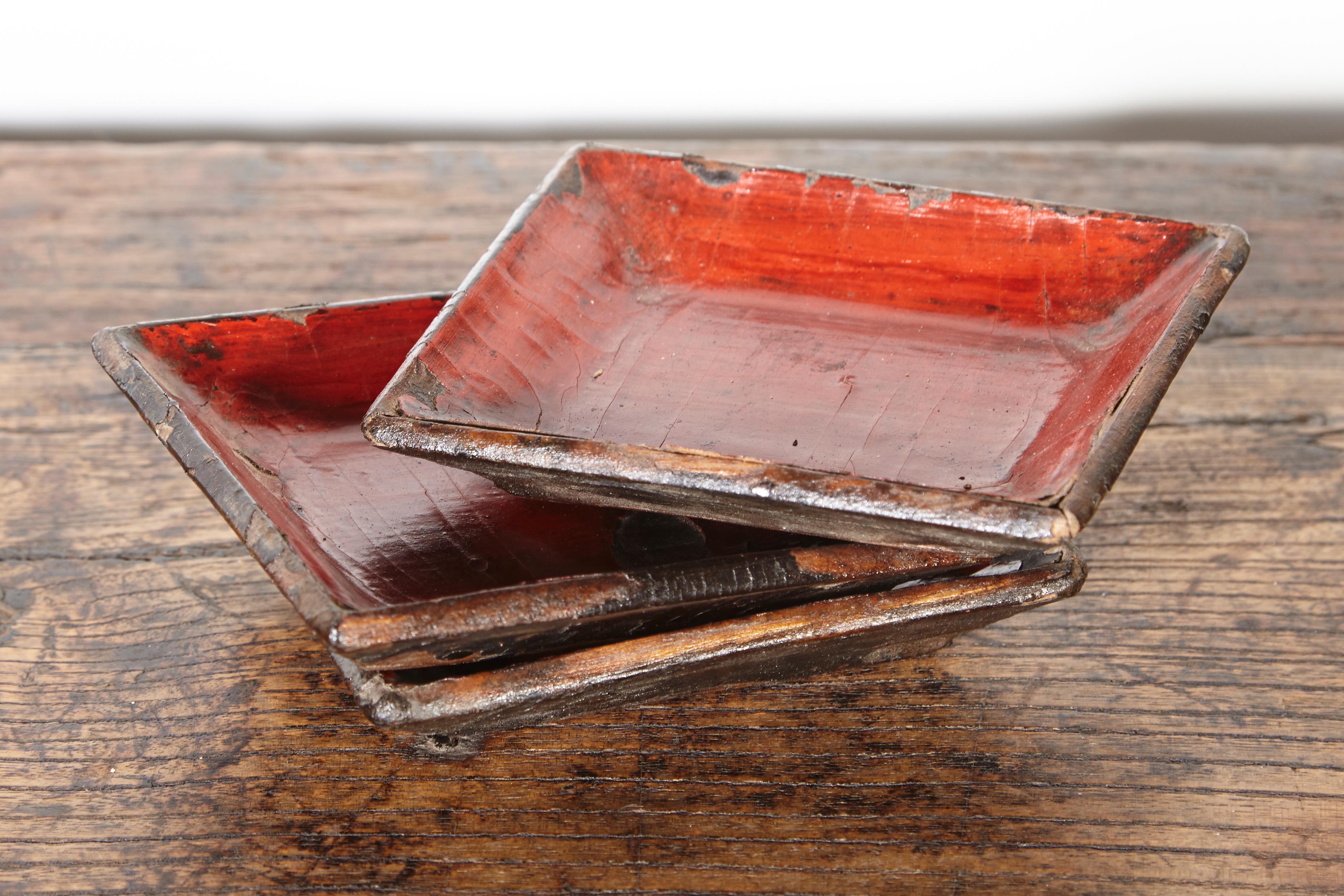 A wonderfully worn set of three small mid-19th century wood and red lacquer trays with much of the original thick, red and black lacquer remaining. Rarely seen in this condition. These trays work perfectly for many uses, including to hold your small