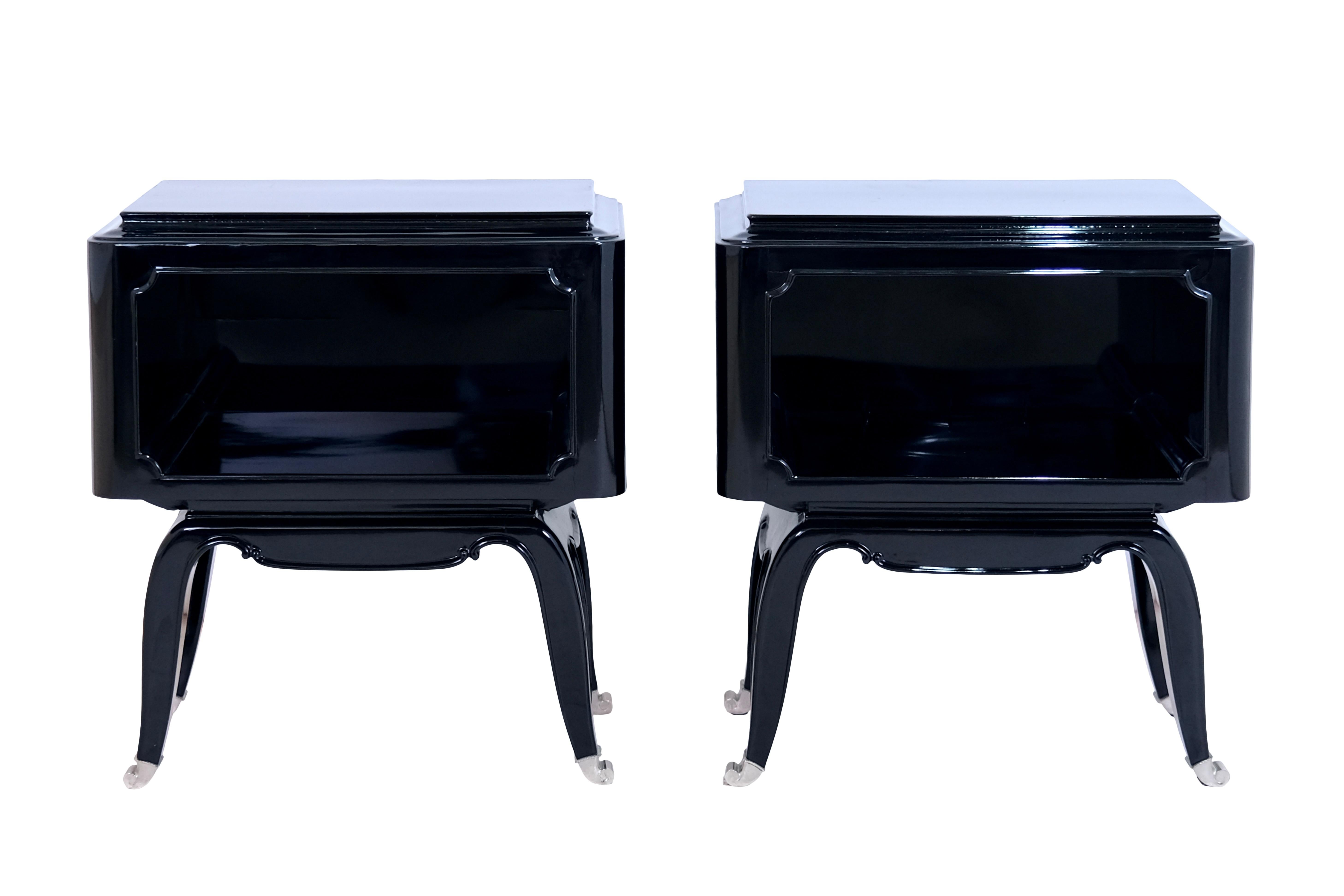 Pair of open bedside tables 
High gloss black piano lacquer
Nickel plated metal sabots on all legs

Original Art Deco, France 1930s

Dimensions:
Width: 55 cm
Height: 60 cm
Depth: 38 cm