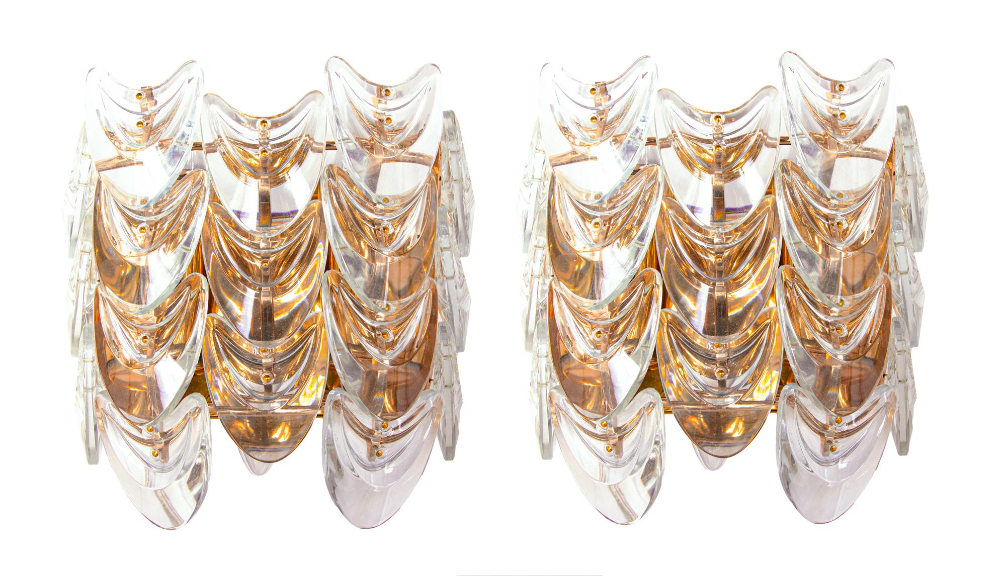 Elegante par de apliques de pared con marco de latón dorado y elementos de cristal. Estas lámparas tienen un carácter único incomparable. Un toque de lujo llena la habitación. 
 
Fabricante: Palwa, Palme & Walter, Alemania, años 60. 
Medidas: altura