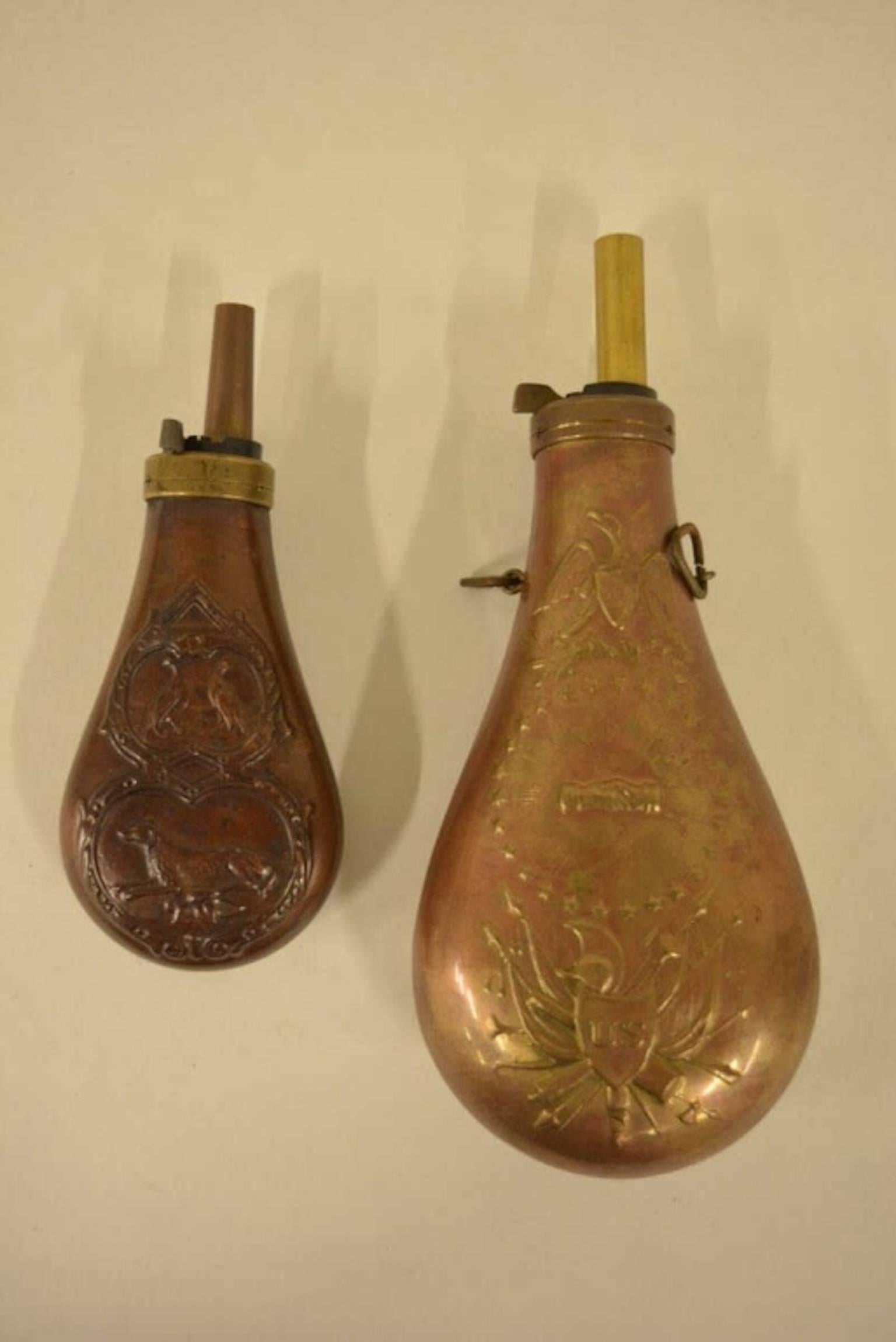 Nice lot of two antique gun powder flasks. Neither of the flasks have makers marks.
The larger flask has the civil war eagle and the other has a hunting dog motif.
Largest flask measures approximately 9 inches long by 4 inches across
Smaller