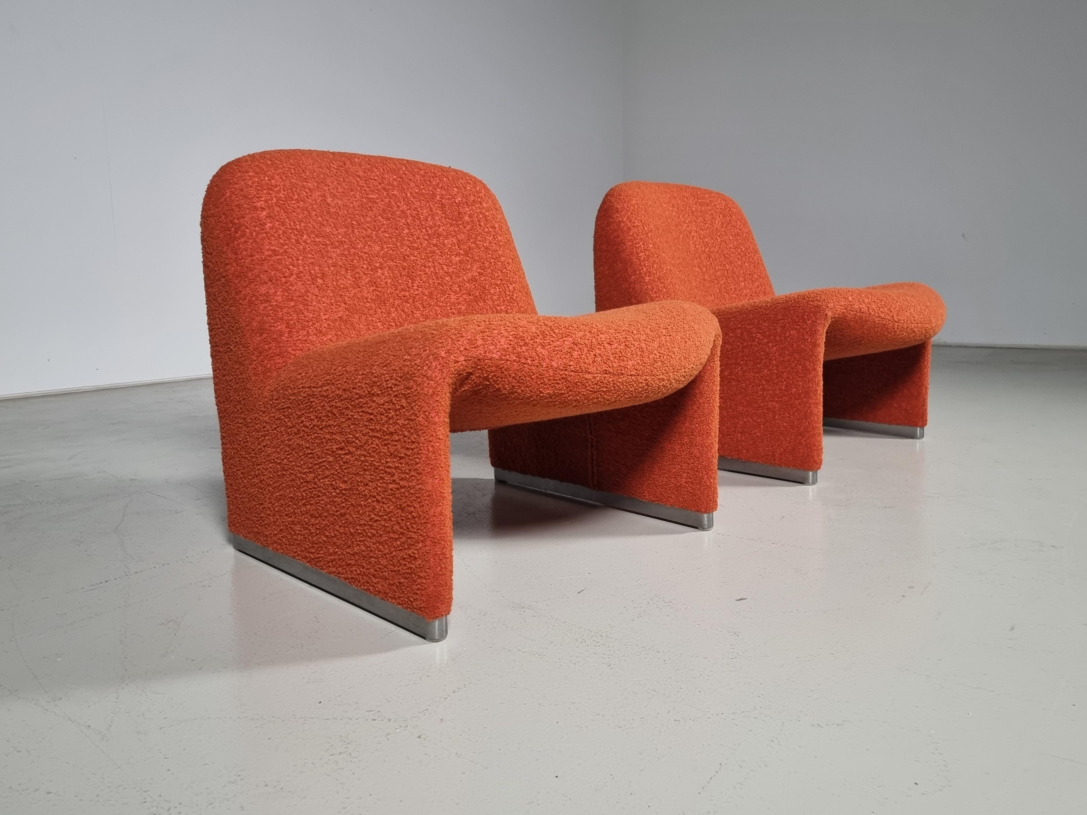 Giancarlo Piretti designed lounge “Alky” chairs newly upholstered in a high-end rusty red/orange cotton/wool Bouclé. Aluminum frame and polished chrome footrests. Beautiful organic curves are reminiscent of Pierre Paulin's designs. Produced by