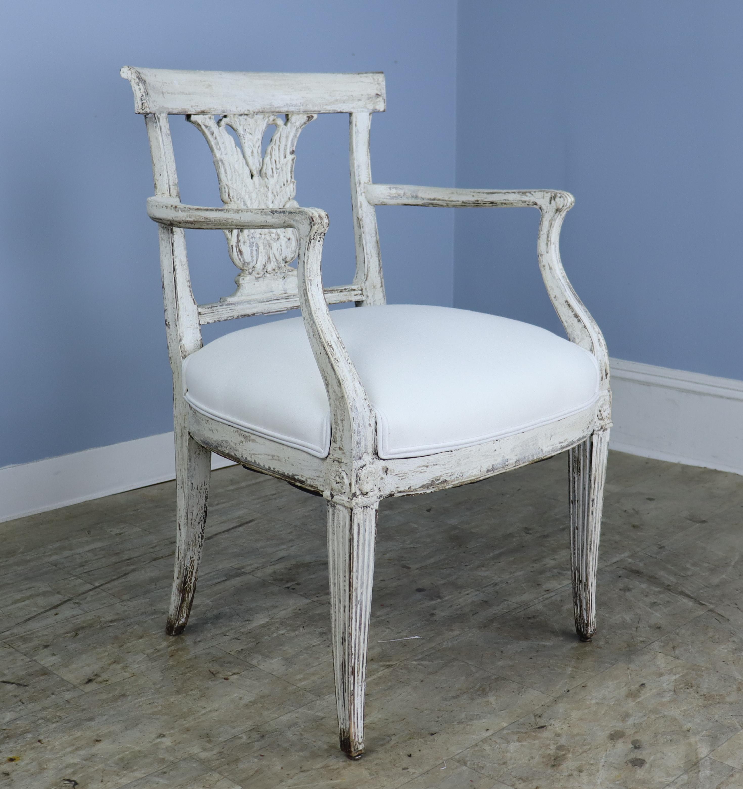 A set of 8 French Empire period wooden chairs, 2 armchairs and 6 side chairs. Note the graceful swan motif on the chairbacks, and the charming flower detail at the joints. We believe these to be recently painted and faux distressed. The seats have
