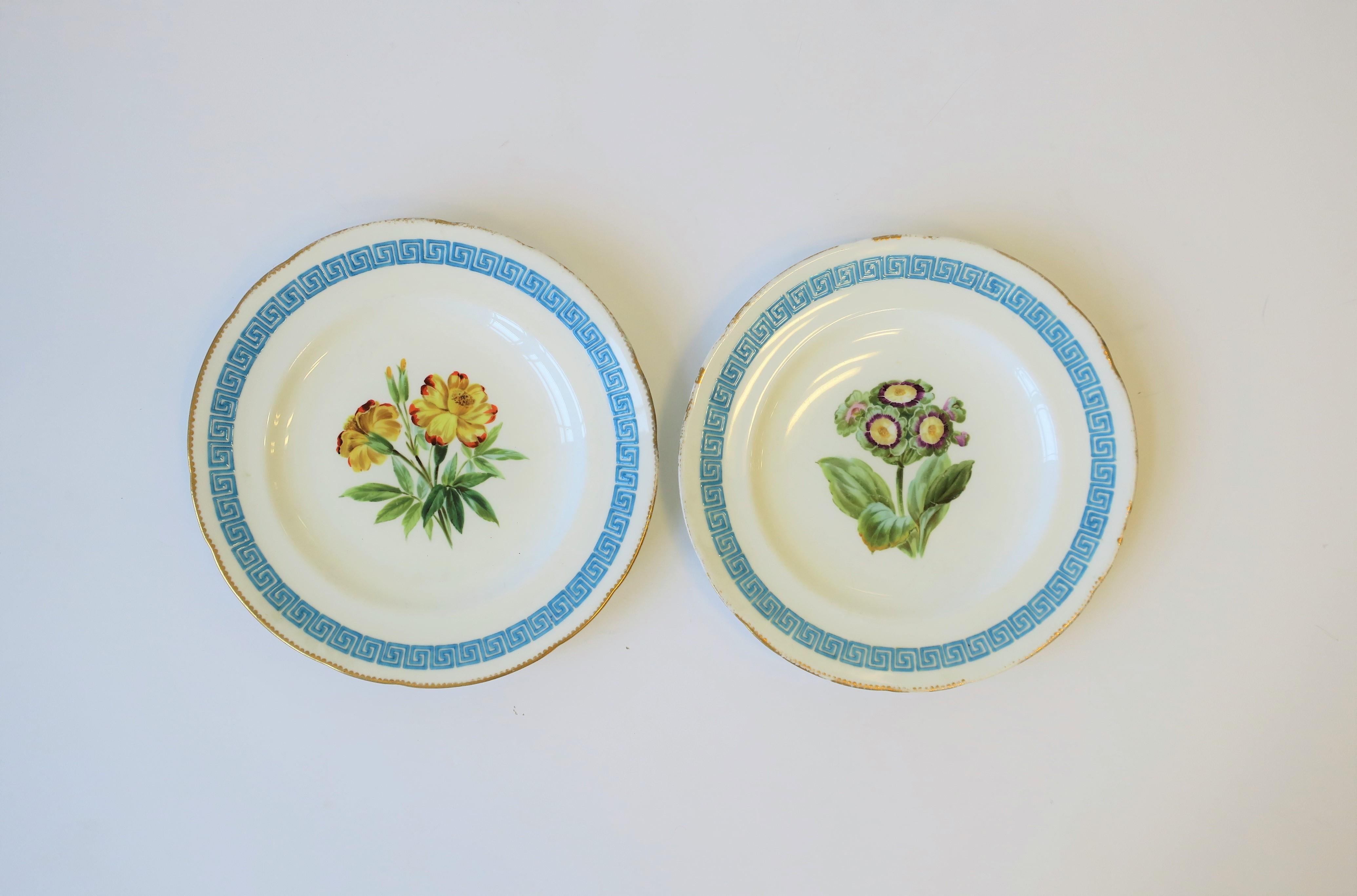 A beautiful set of two antique English Minton hand painted porcelain plates with a floral and Greek key design, finished with a gold trim, circa early-20th century, England. Greek-key design around plates edge is slightly raised. Colors include: