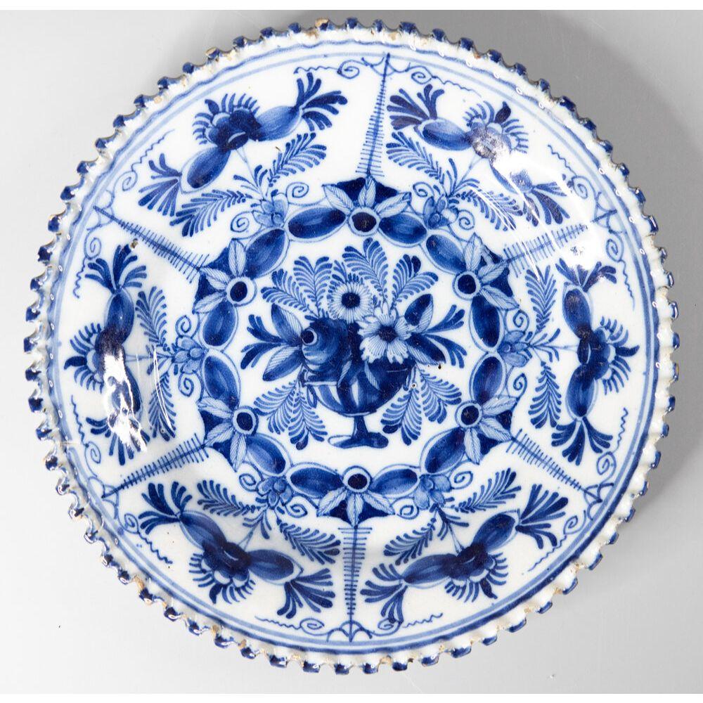 A gorgeous near pair of antique 18th-century Dutch Delft faience floral plates with rare scalloped rims. These lovely plates have a hand painted flower pot center with decorative floral and foliate border and lovely ruffled edges in vibrant cobalt