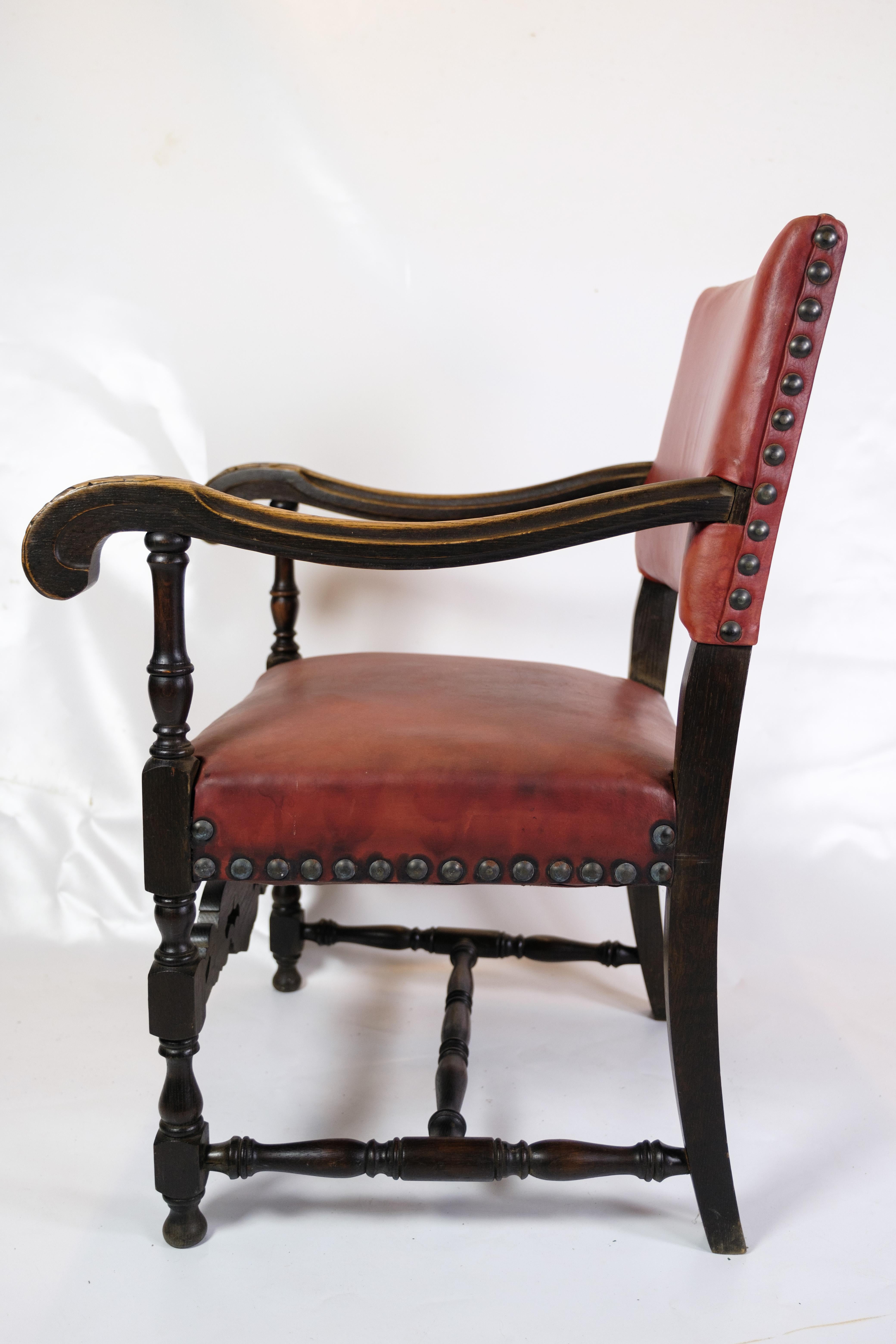 This set of two antique armchairs from 1930 is a wonderful combination of genuine craftsmanship and timeless elegance. With their red leather seats and oak frame, these chairs exude a unique vintage charm and warmth. The solid wooden construction