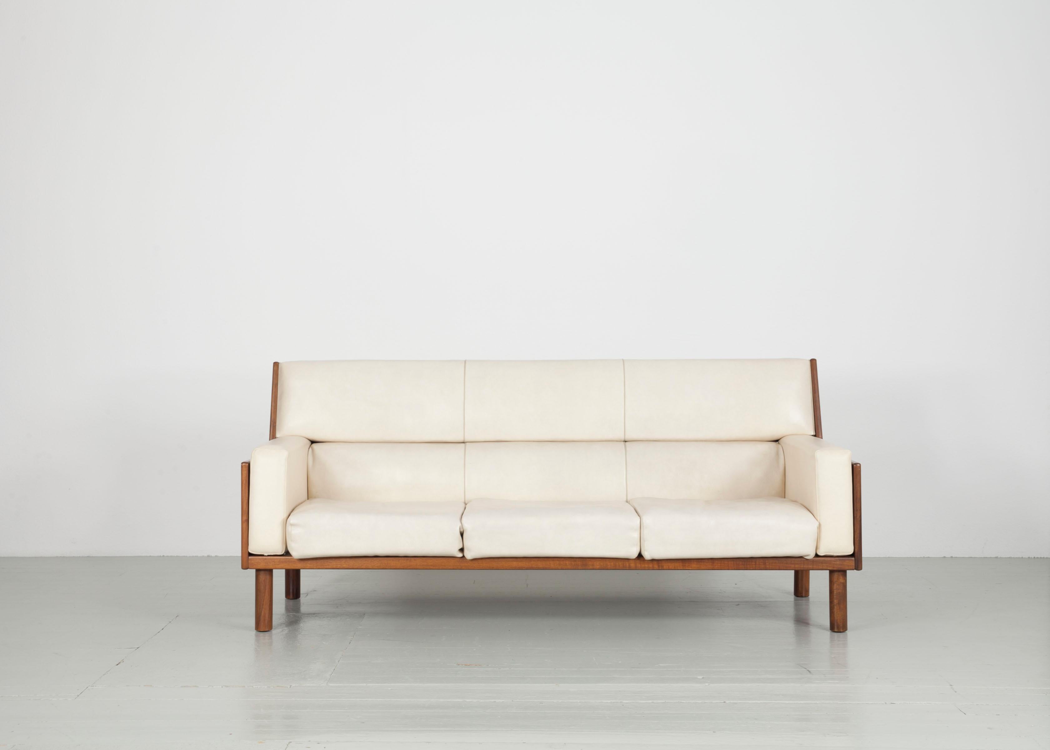 Dieses Set aus Sesseln und einem Sofa wurde in den 1960er Jahren von Anonima Castelli in Italien hergestellt. Die Garnitur besteht aus zwei Sesseln und einem dreisitzigen Sofa. Das weiße Kunstleder harmoniert wunderbar mit dem warmen Mahagoniholz