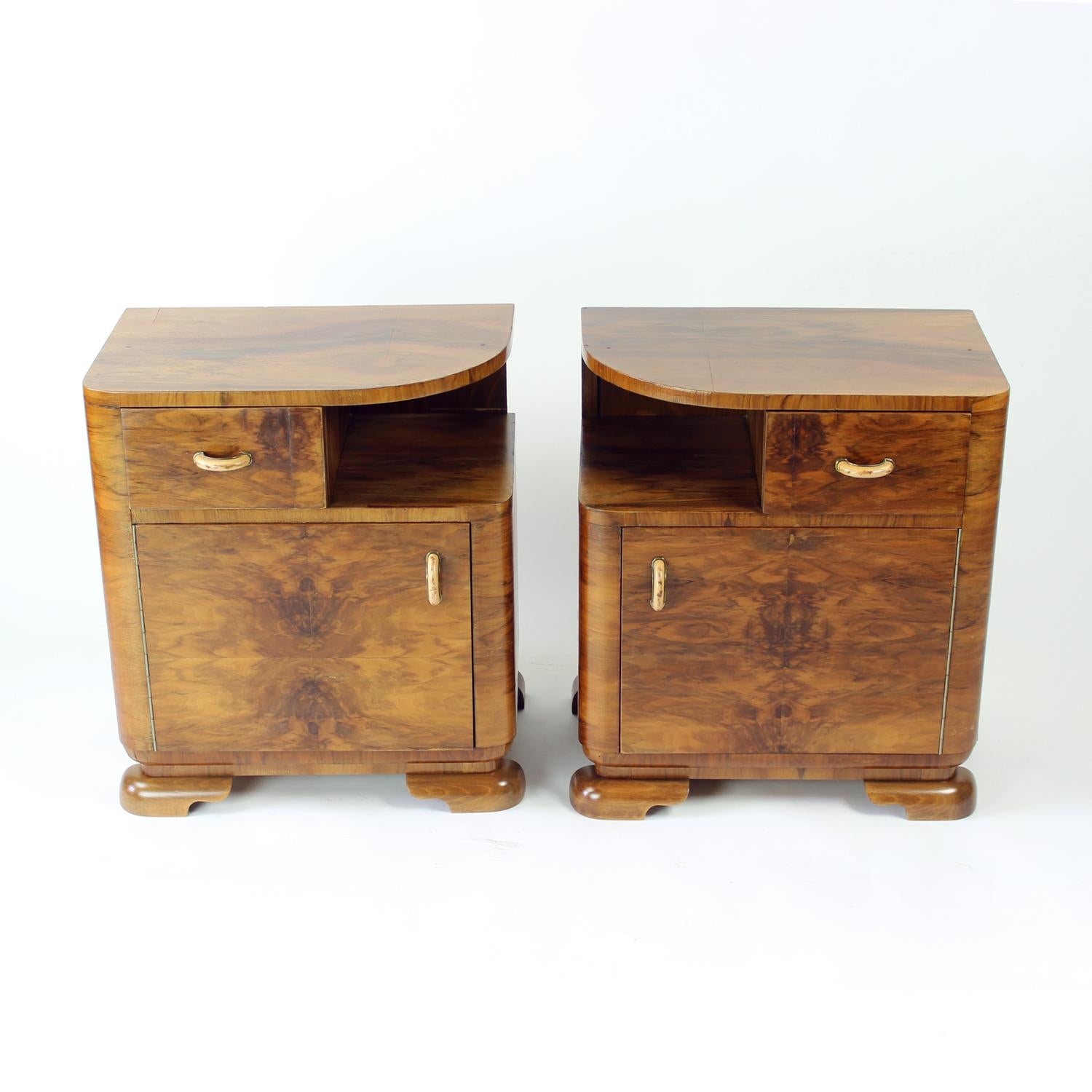 Beautiful and completely restored set of two bedside tables from the art deco period of design. Produced in Czechoslovakia in 1930y, the set is made of oak wood with walnut veneer. The tables were completely refinsihed and restored. Original handles