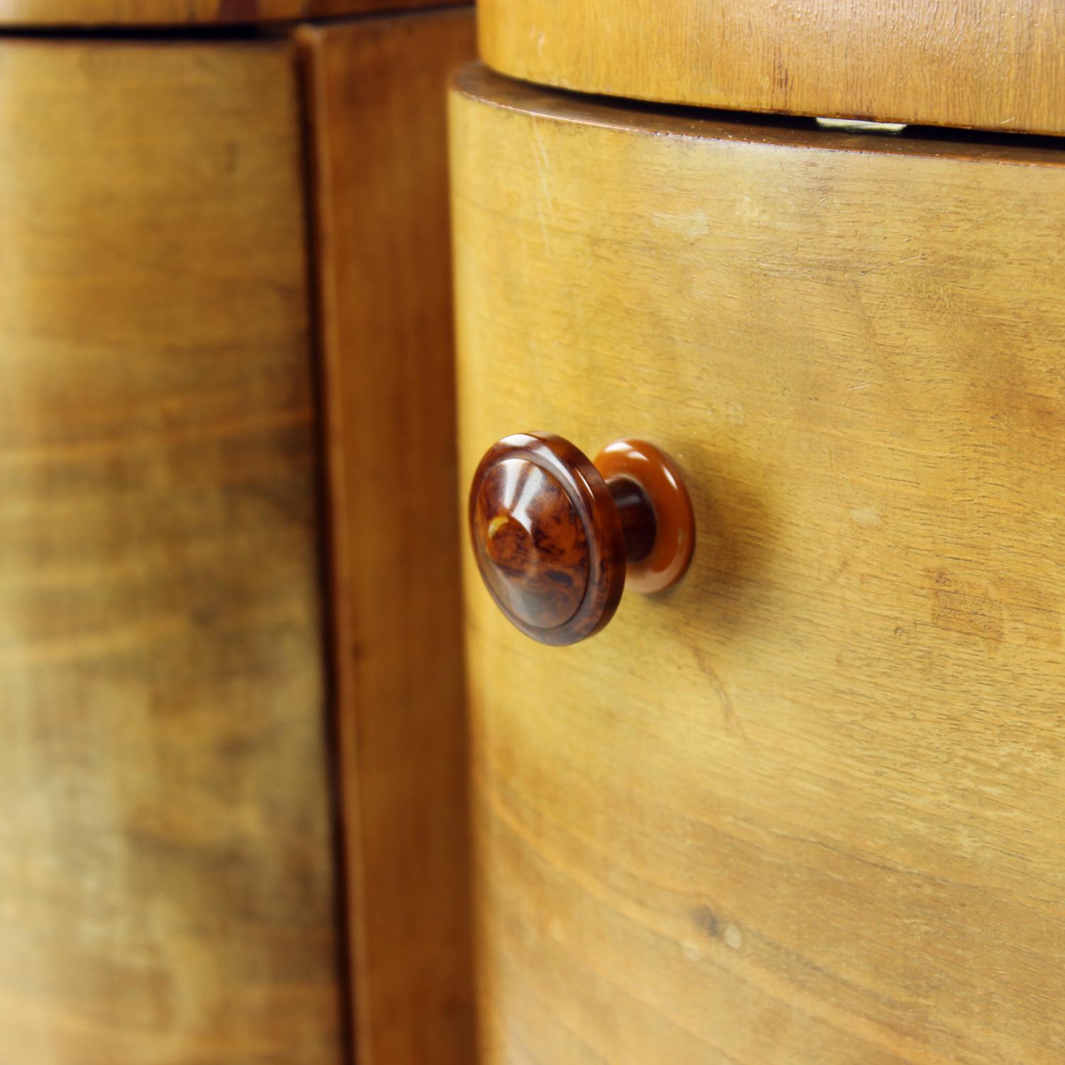 Beautiful set of two bedside tables from art decó period in 1940s. Produced in Czechoslovakia, the tables are full of beautiful details. The front side, the front door and top board are curved with beautiful, elegant lines. The handles are original,