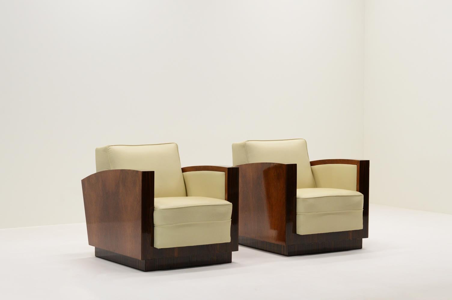 Ensemble de 2 fauteuils club Art déco, France, années 1930 Les chaises sont fabriquées avec 3 types de placage de bois dur tropical laqué et revêtues d'un cuir blanc crème. Design/One minimaliste et typique de l'art déco français. Usure conforme à