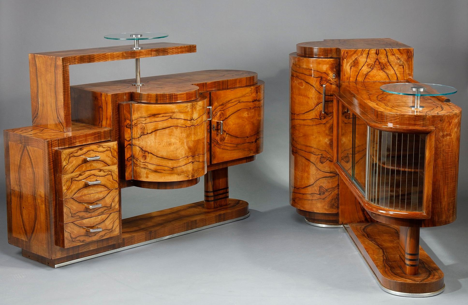 Bar e credenza d'epoca Art Déco in noce e impiallacciatura di noce. Una si apre con due ante e quattro cassetti, l'altra con un'anta cilindrica e ante scorrevoli in vetro. Base e maniglie cromate. La loro forma architettonica evoca le forme e le