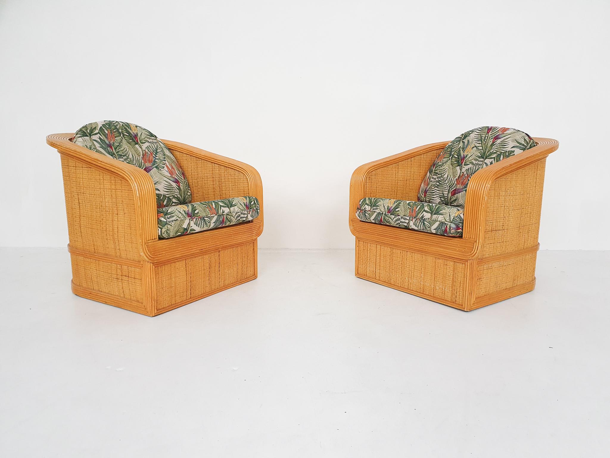 Set of two bamboo and rattan lounge chairs in the style of Paul Frankl. We have reupholstered the cushions in a new flower pattern fabric.