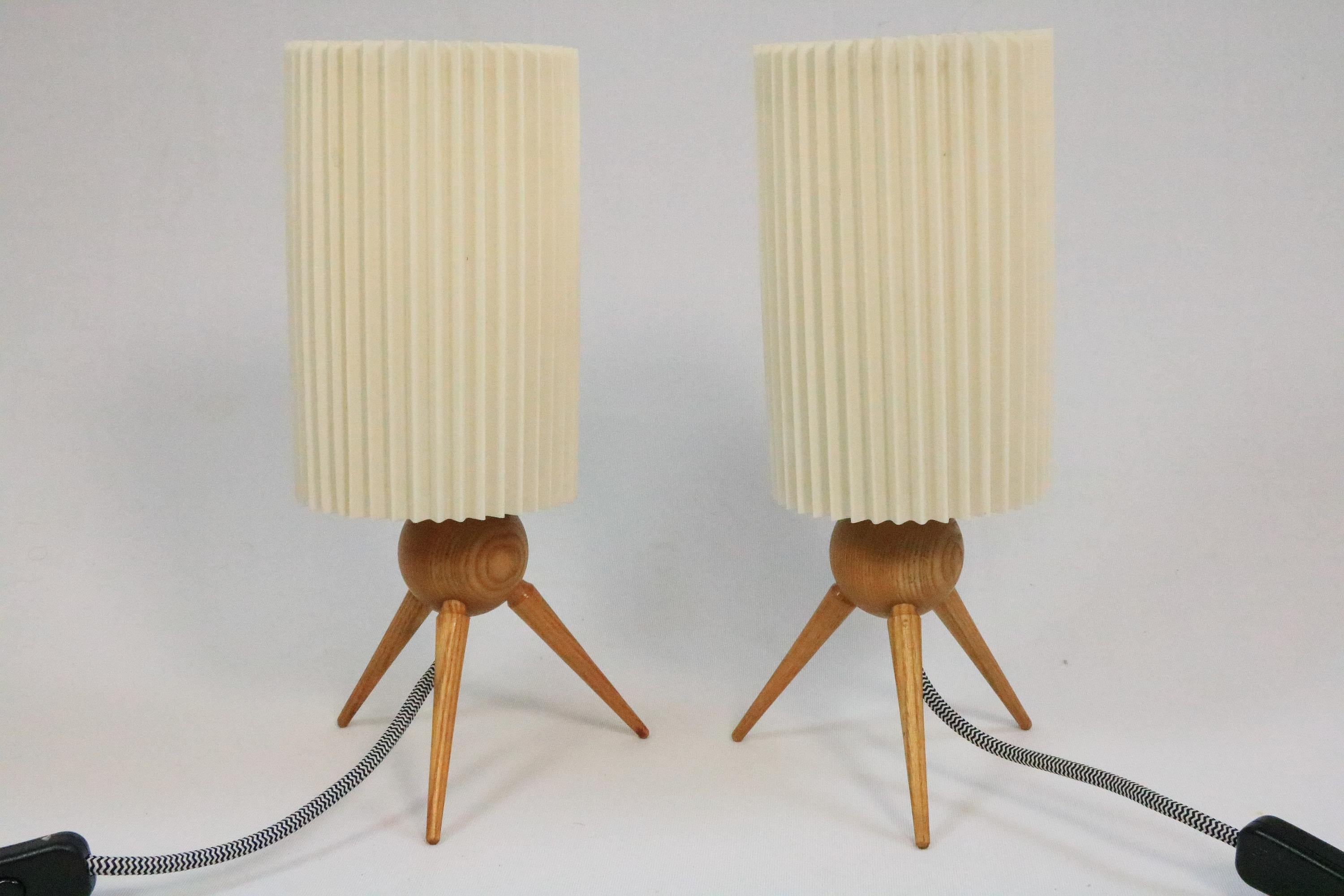 Two very charming table lamps, originals from the 1950s.

The cables have been renewed, but with the same design as the original cable (black and white textile cable).

The plissee shades make a pretty light and are well preserved. They were sticked