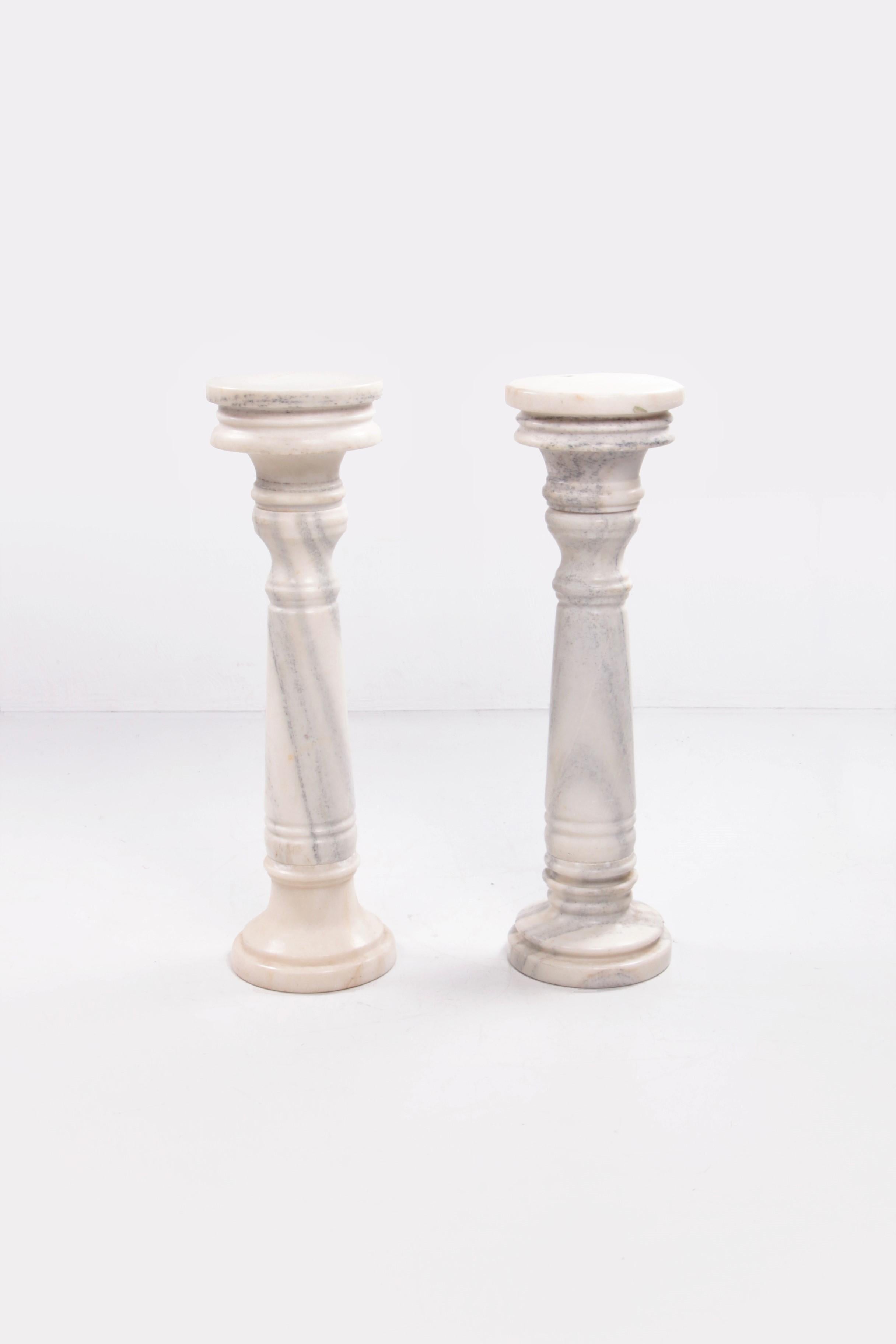 Set of 2 beautiful white gray veined marble pedestals France 1920.

This is a set of 2 white veined marble pedestals in the shape of a column with a fluted shaft. The ringed capital is covered with a round top on which a sculpture or clock can be