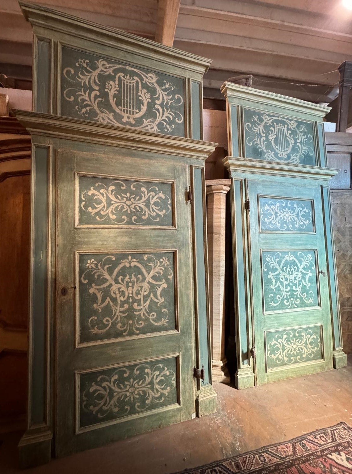 Conjunto de 2 grandes puertas antiguas de interior, ricamente pintadas con colores marfil sobre fondo azul claro/verde, completas con marco y sobrepuerta originales, de madera maciza lacada con tres paneles pintados.
Puertas de una hoja, de doble