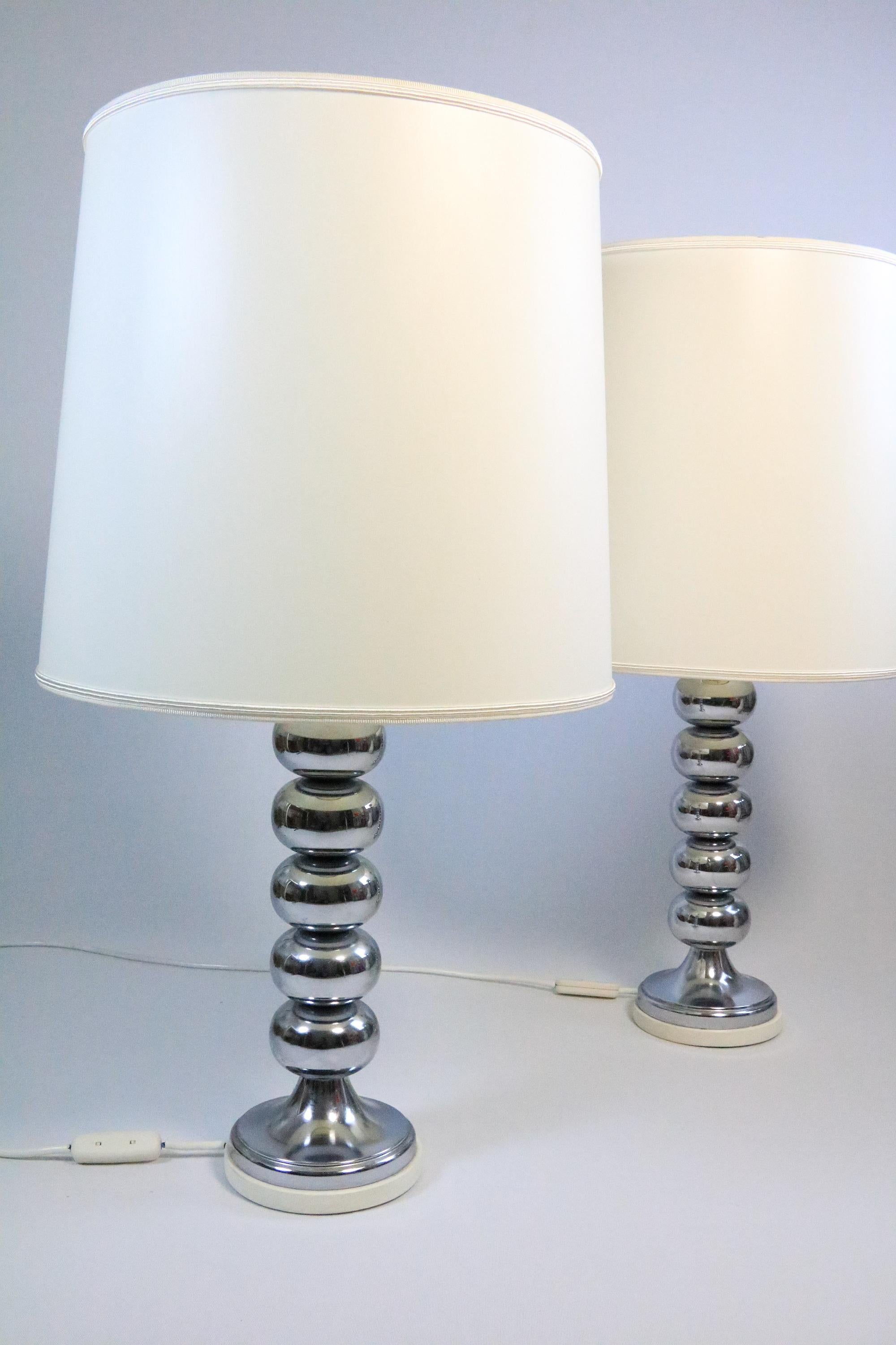 Impressive, large table lamps from the 1970s.
With chrome base and newly covered lampshades.
 
In very good condition, with slight signs of wear. A small crease in the shade which is only visible when the light falls at an angle.
The upper cover is