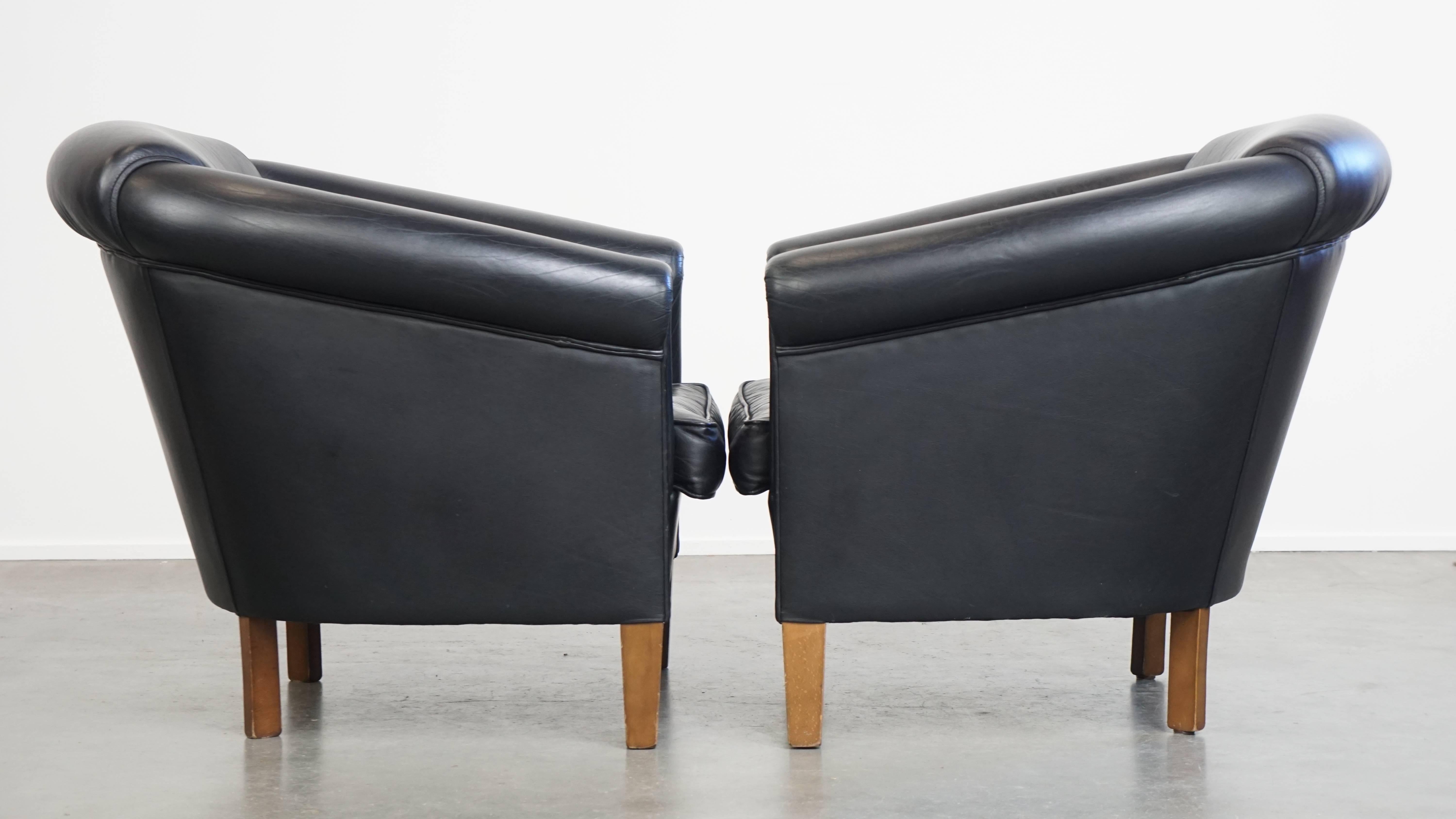 Offered here is this beautiful set of 2 black cowhide leather club armchairs in English style with a timeless design. 

With their elegant black color and classic lines, these armchairs are true eye-catchers that suit almost any interior style.

The