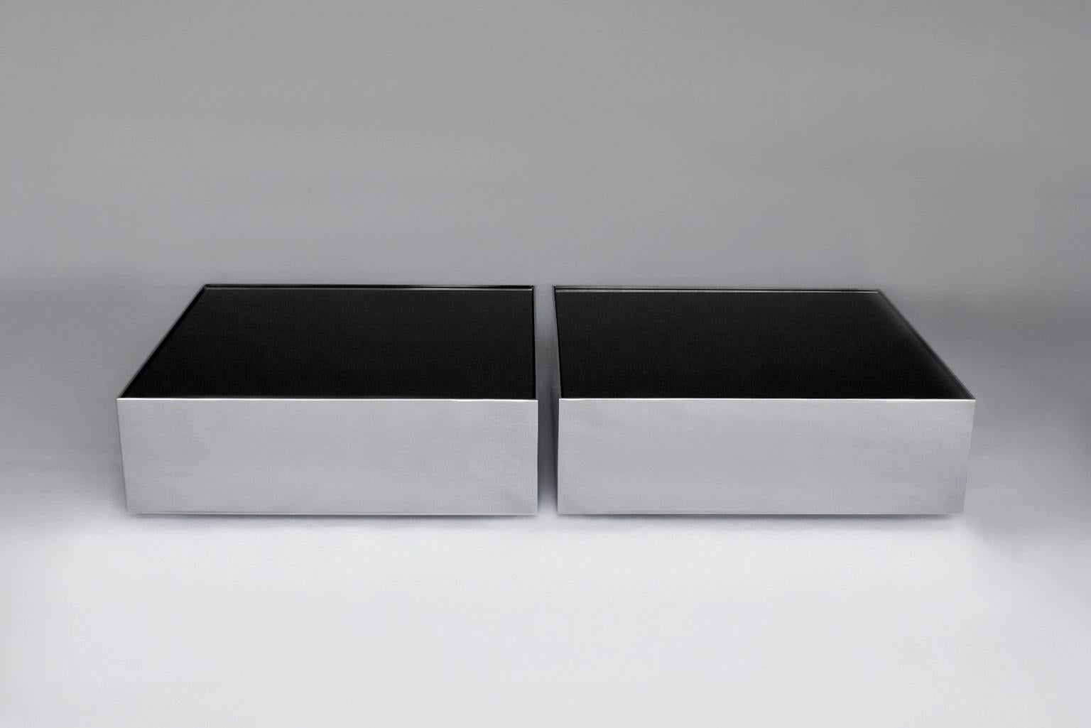 Ensemble de 2 tables basses à glace noire par Phase Design
Dimensions : P 76,2 x L 76,2 x H 25,4 cm.
MATERIAL : Verre de tympan et métal chromé poli.

Table basse en acier avec plateau en verre spandrel. Disponible en finition chrome poli ou