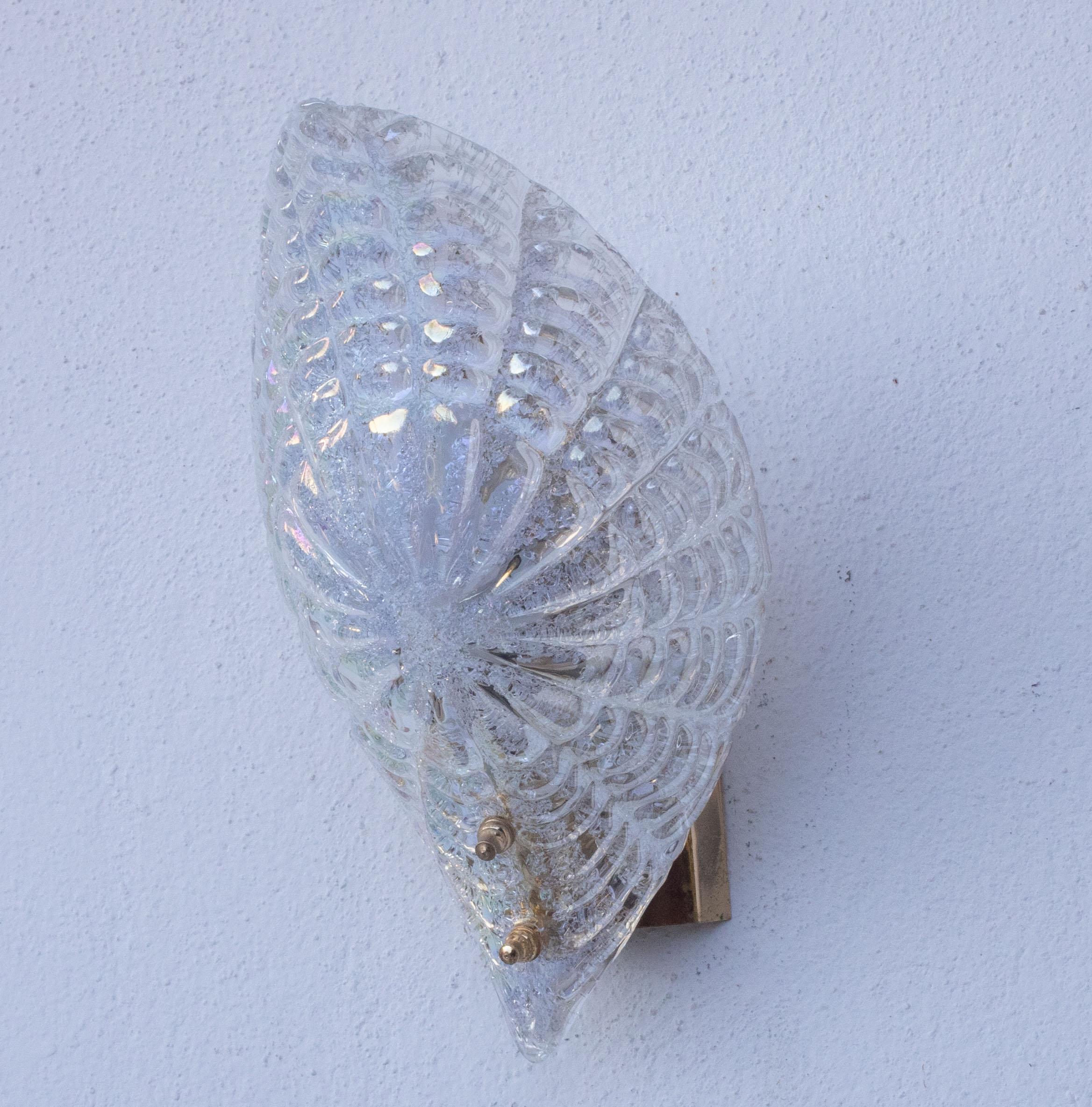 Wunderschönes Set aus 2 Murano Wandleuchten in schillernder Farbe, die je nach Umgebung ihre Farbe ändert.
Die Leuchte besteht aus einem Glasblatt und einem Metallrahmen in Goldbad, das Blatt ist perfekt, stattdessen haben die Rahmen das Gefühl der