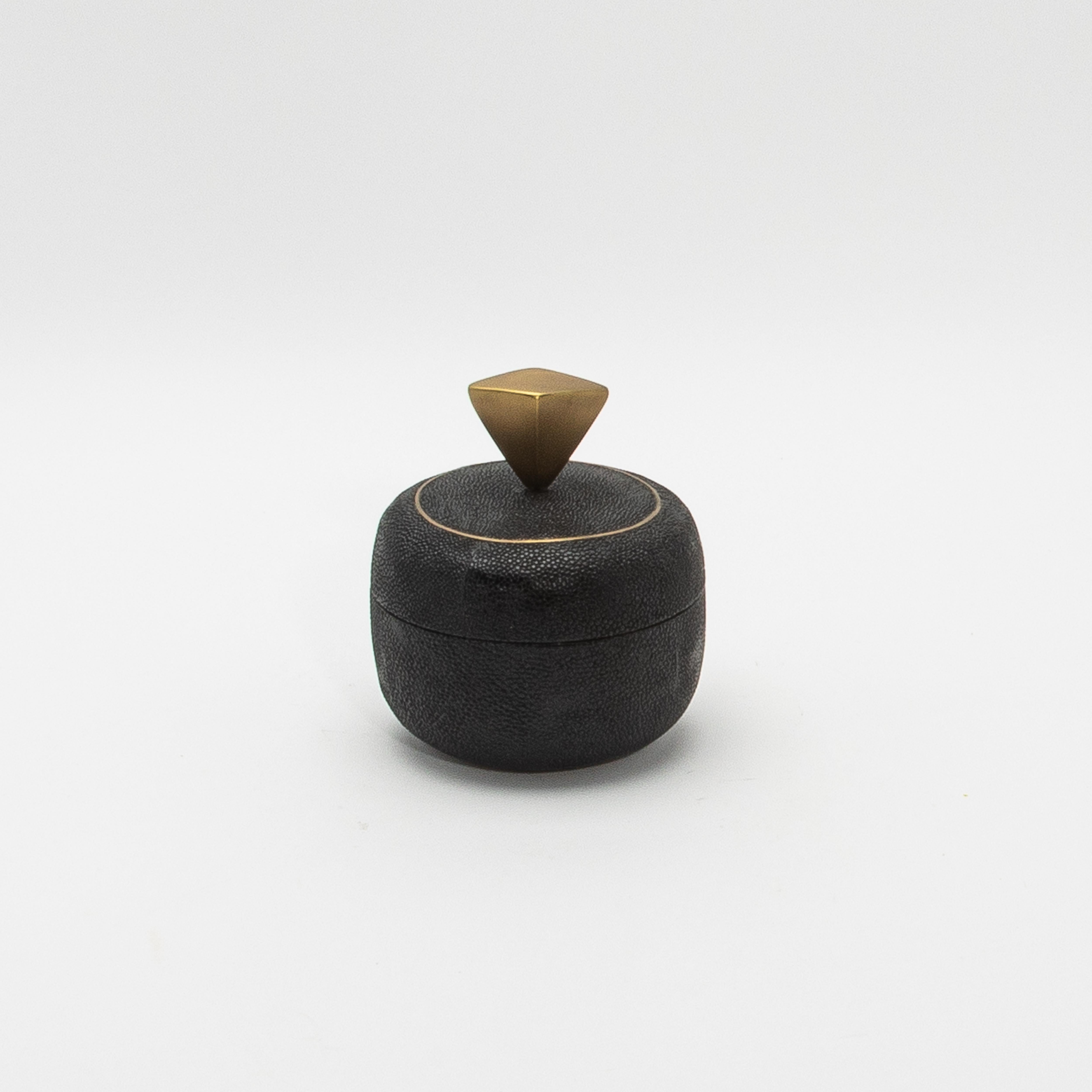 Este exquisito juego de cajas redondas de Kifu Paris, fabricadas en piel de zapa negra, encarna el lujo discreto con su textura rica y mate que resalta la belleza natural de este material exótico. La sutil superficie de guijarros de la piel de raya