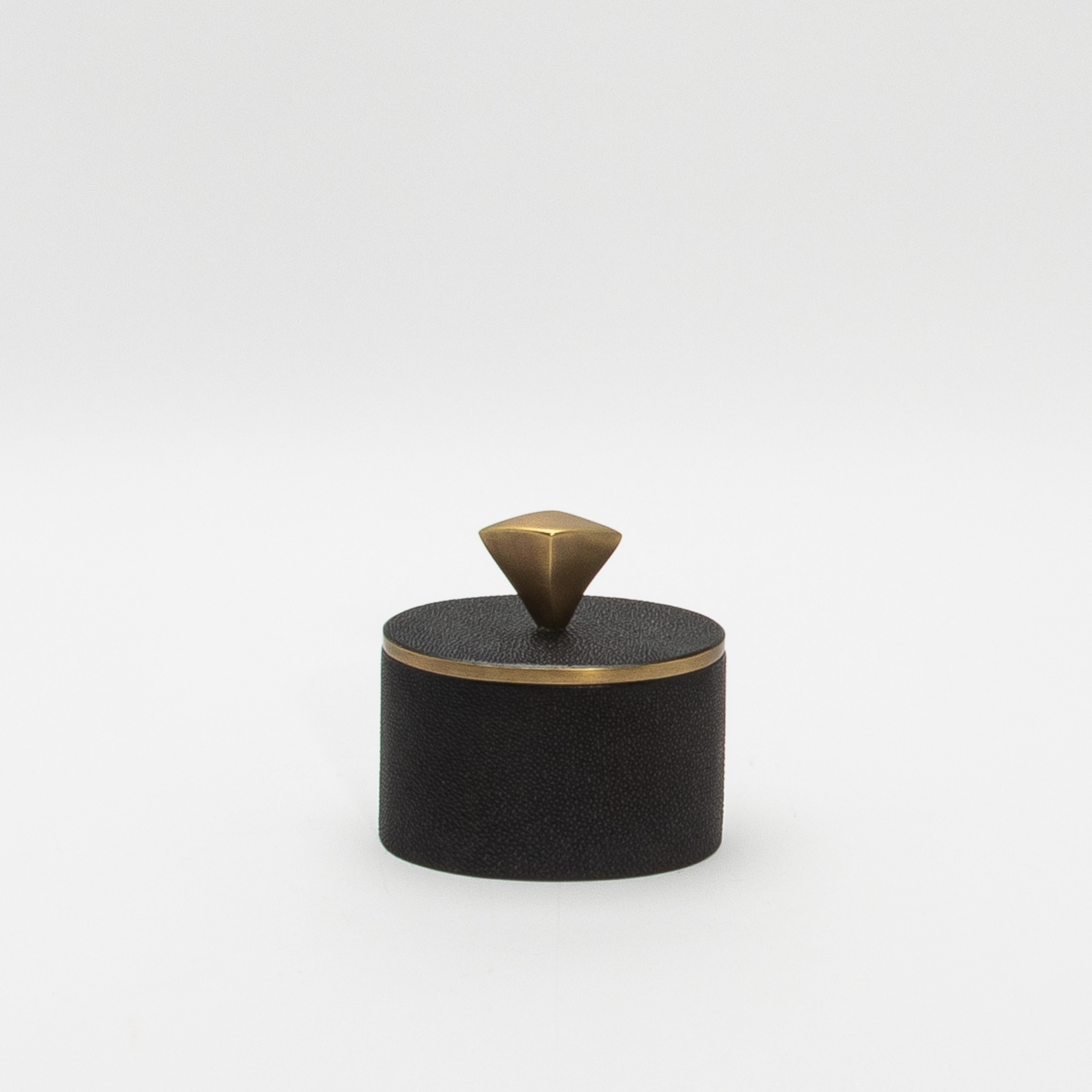 Este exquisito juego de dos cajas de Kifu Paris muestra la lujosa artesanía y la meticulosa atención al detalle por las que es conocida la marca. Hechas a mano en shagreen negro, las cajas ovaladas y rectangulares presentan una textura refinada y