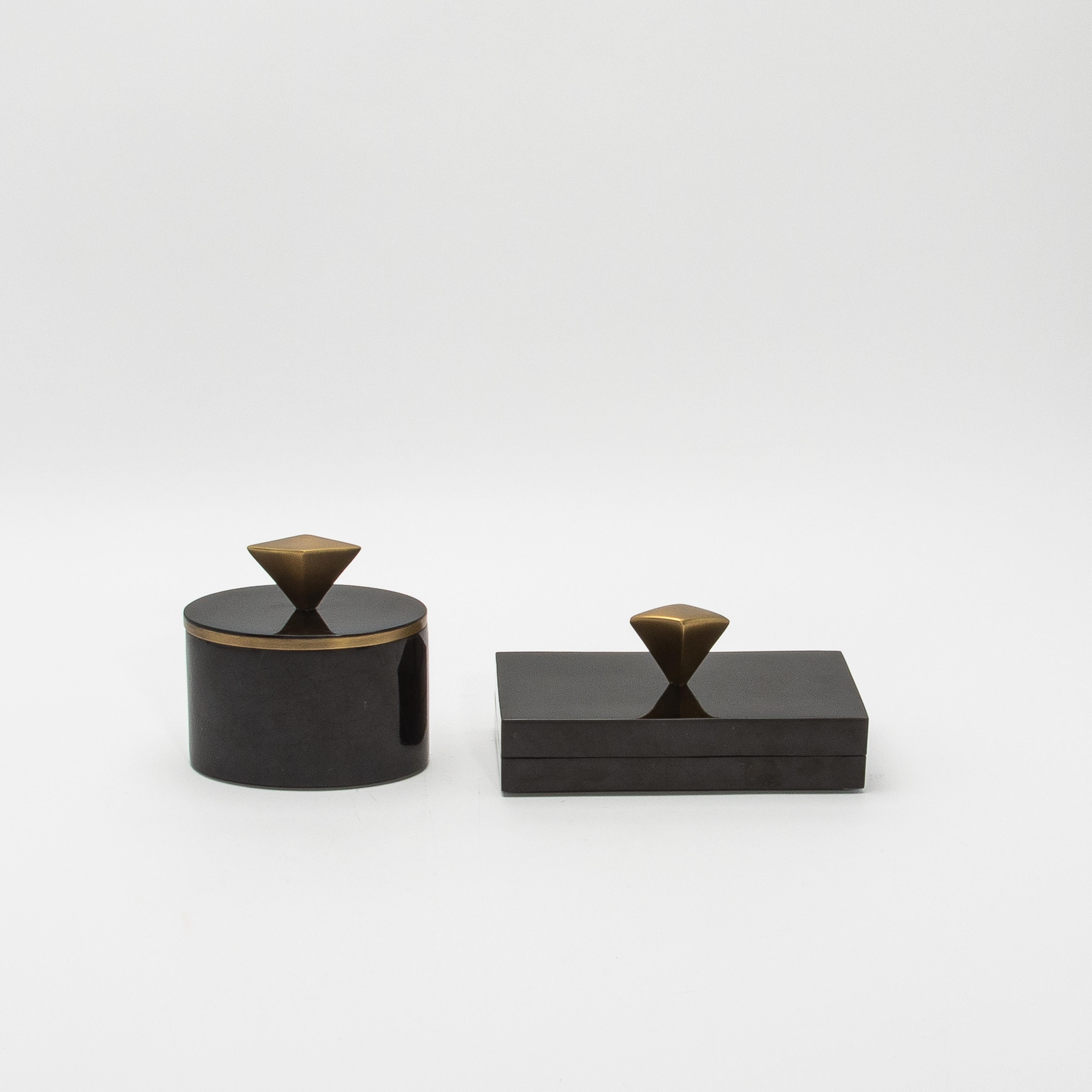 This stunning set of two boxes by Kifu Paris, crafted from luxurious black pen shell, is a masterpiece of opulence and sophistication. The natural iridescence of the pen shell, with its subtle yet captivating reflective surface, enhances the