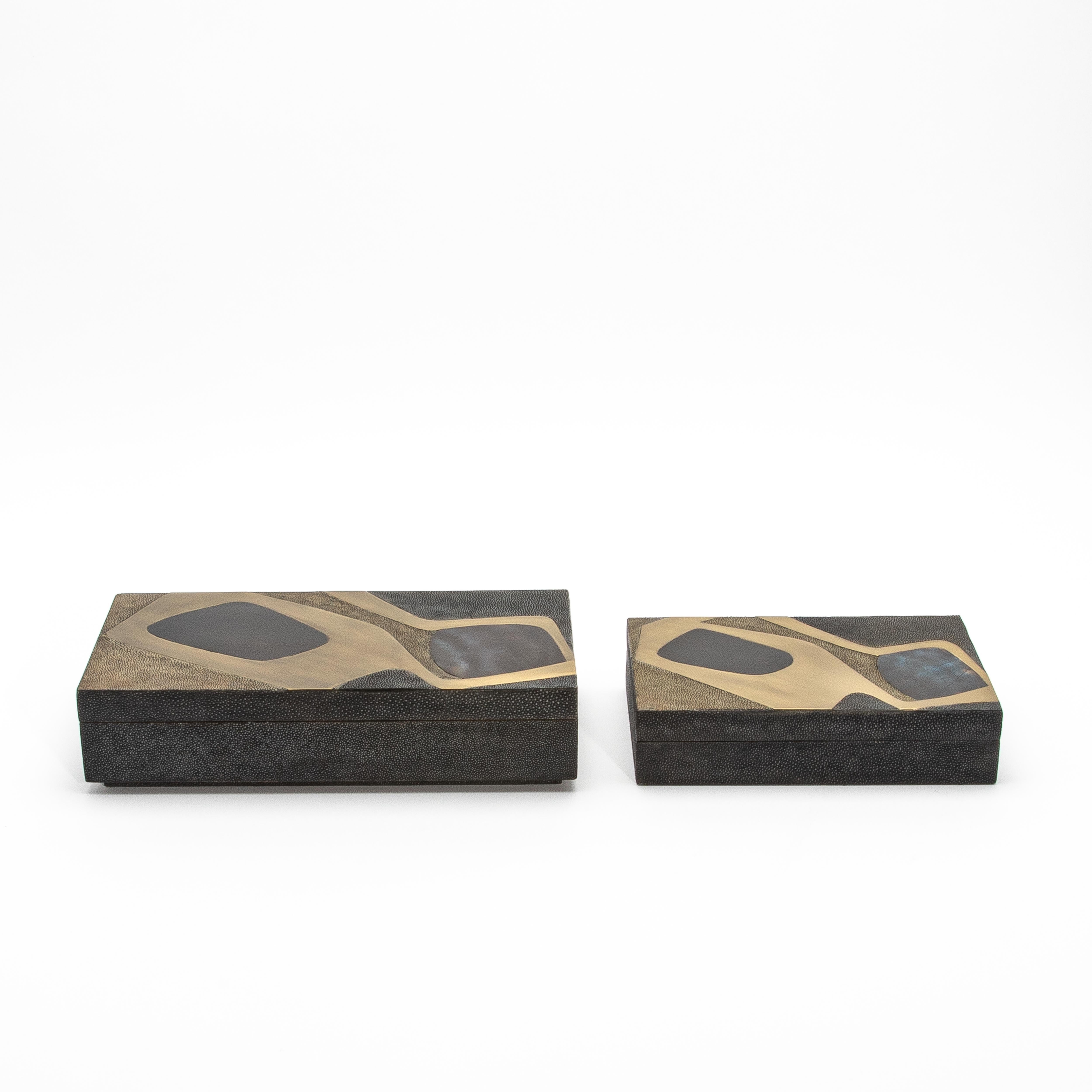 This exquisite set of two rectangular boxes is masterfully crafted from antique shagreen, showcasing a unique cosmos pattern that elegantly marries modern design with classic luxury. Each box features intricate inlays of mother-of-pearl and brass,