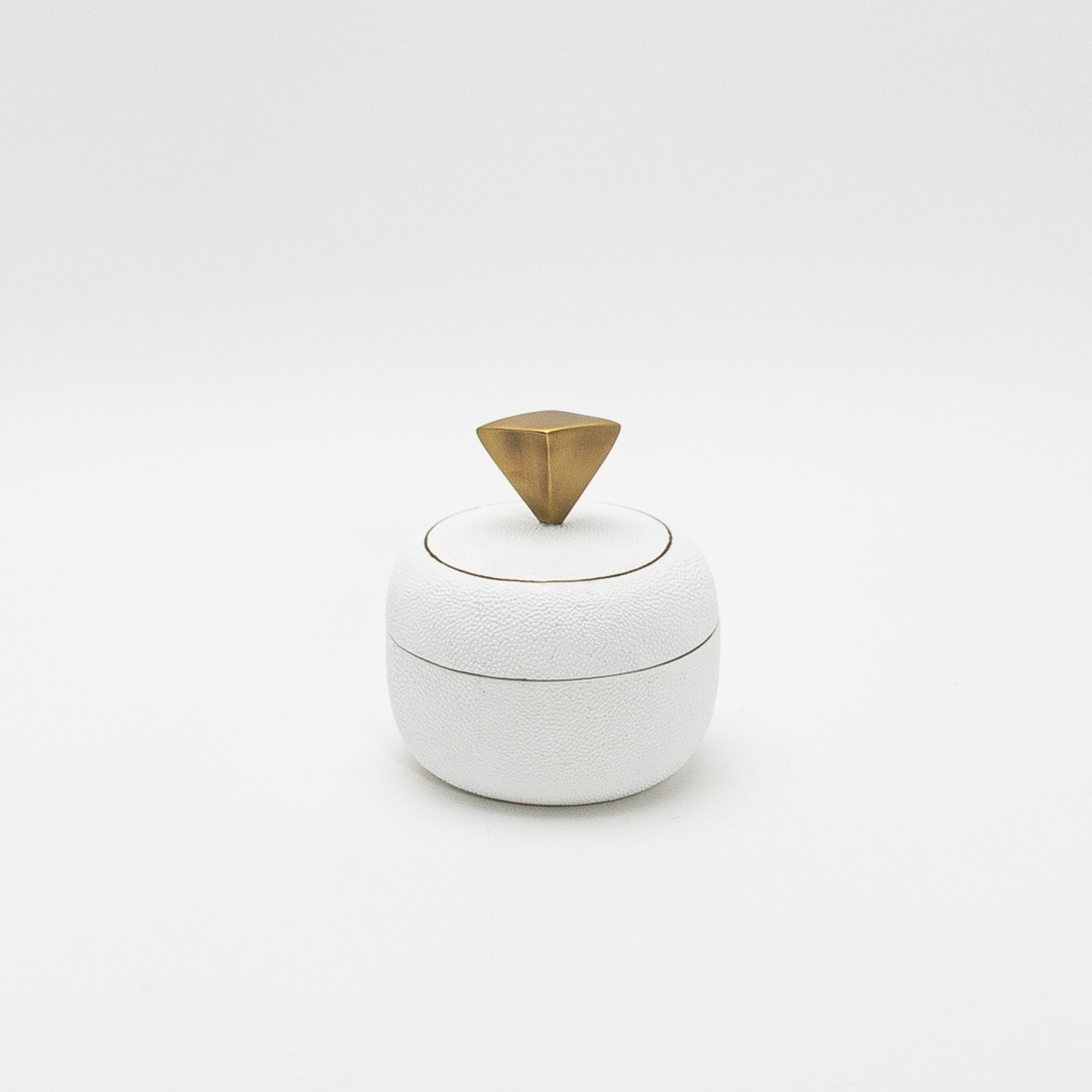 Este exquisito juego de cajas redondas de Kifu Paris, fabricadas en piel de zapa blanca, encarna el lujo discreto con su textura rica y mate que resalta la belleza natural de este material exótico. La sutil superficie de guijarros de la piel de raya